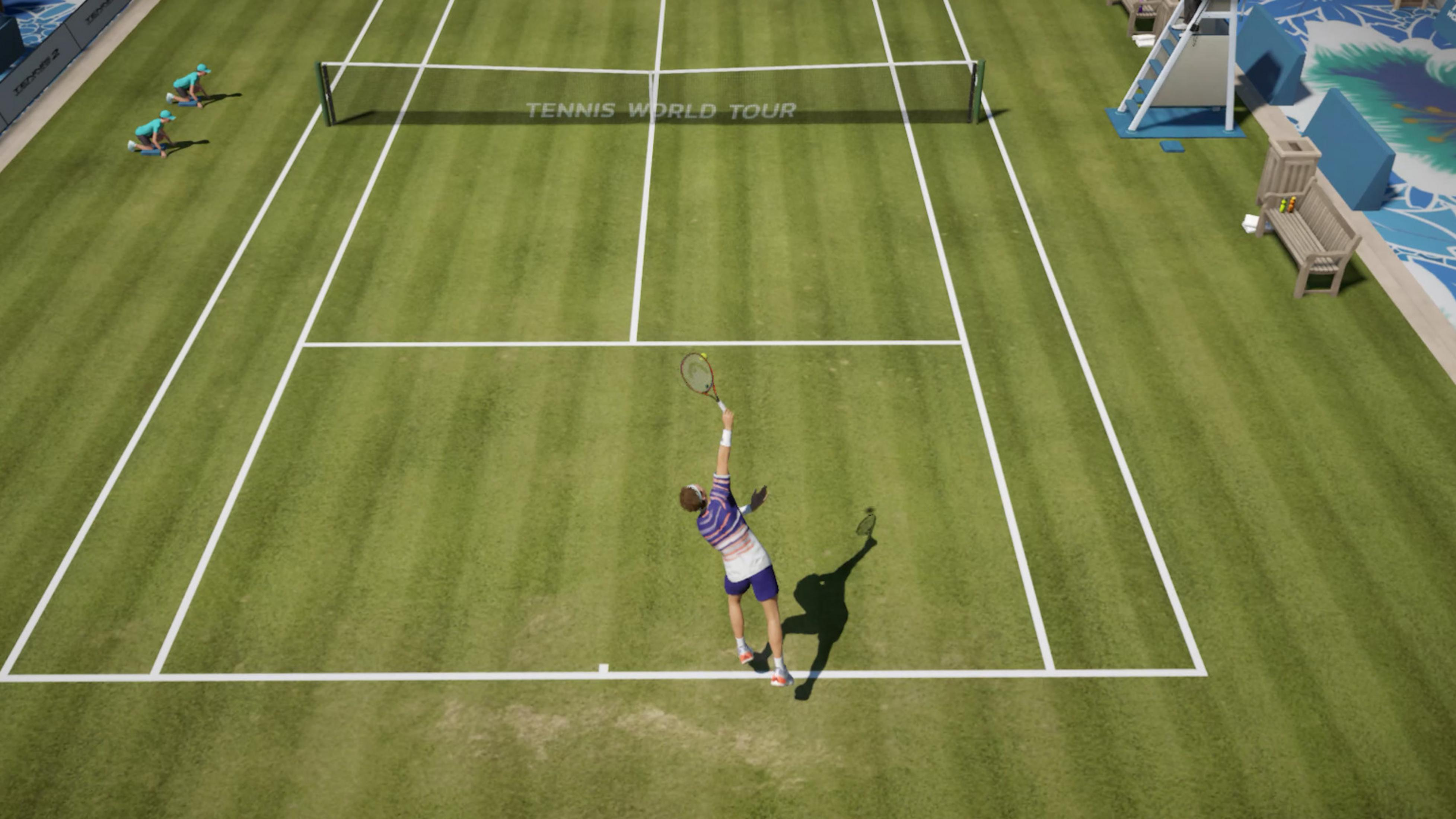 Ein Tennisspieler schlägt im "Tennis World Tour" auf. Zwei Balljungen kauern auf dem Rasen.