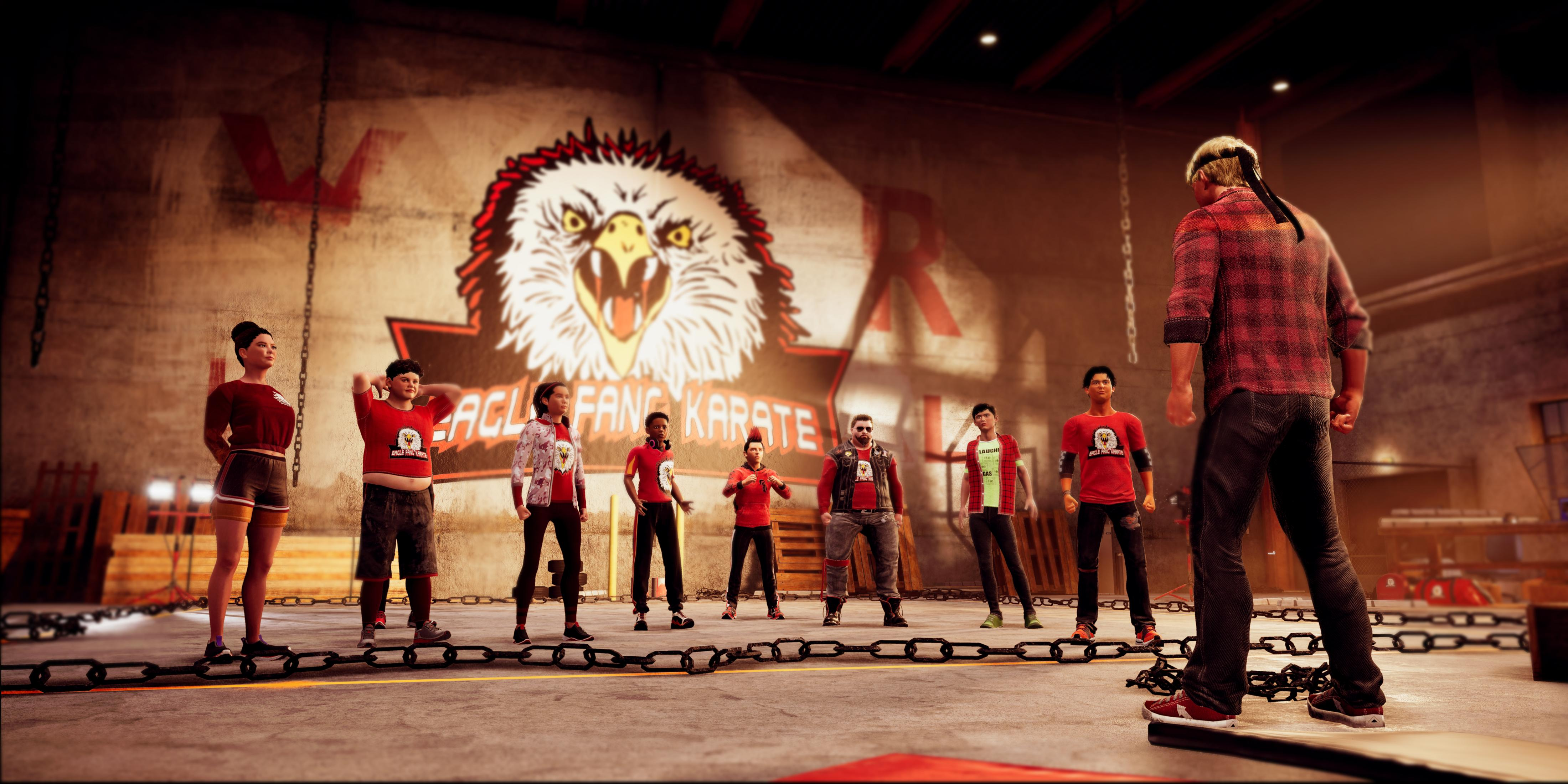 Eine Gruppe von Schülern steht vor einem Adler-Logo. Ein Mann im karierten Hemd blickt weg.
