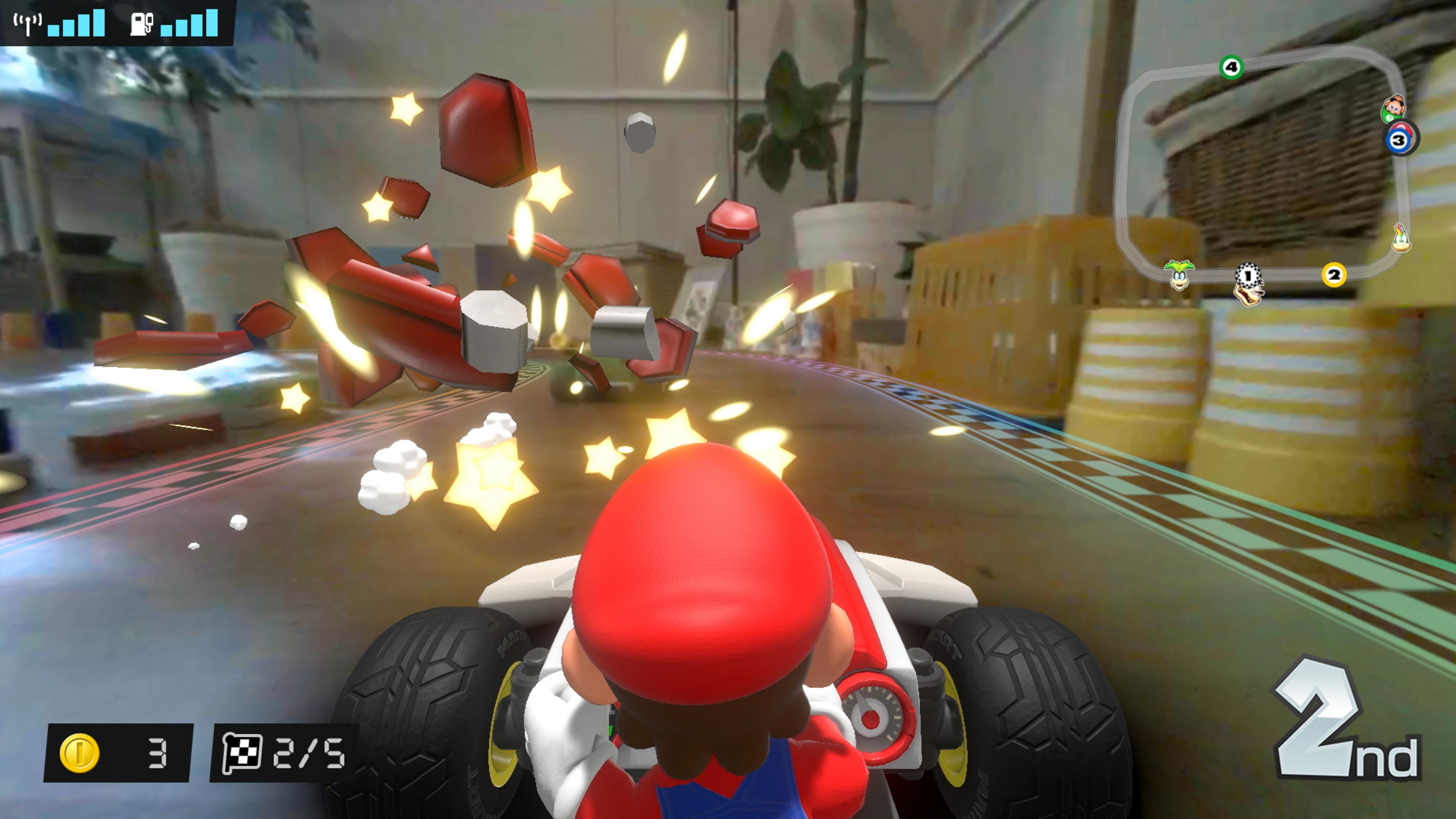 Mario fährt im Kart, rote und silberne Teile fliegen umher, Sterne leuchten.