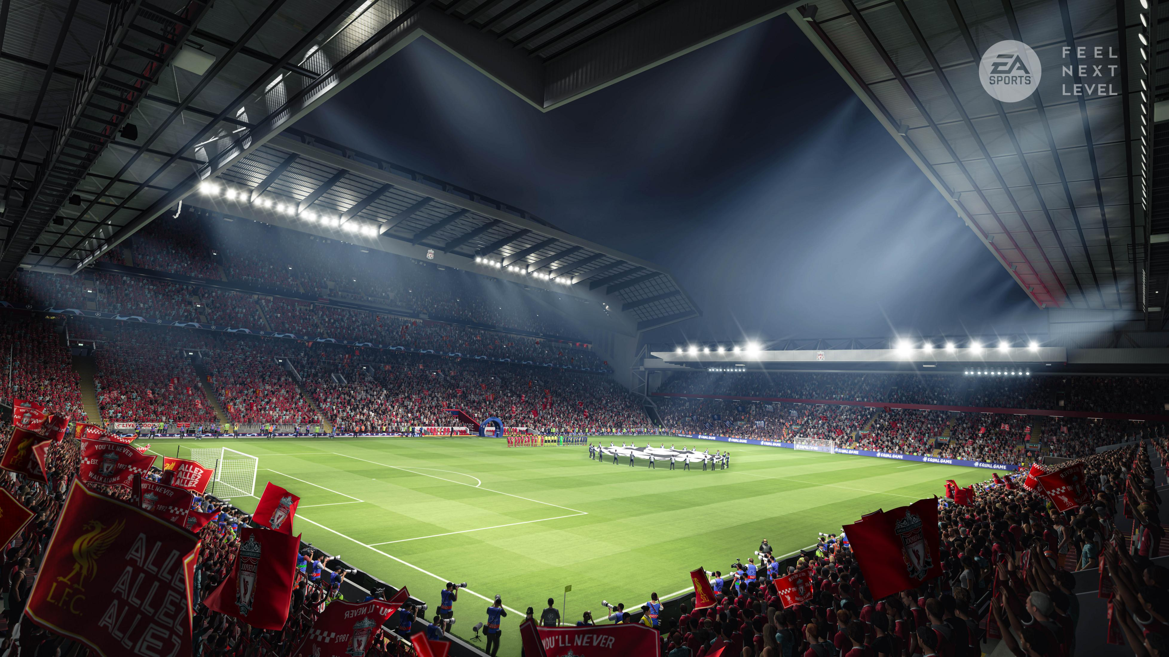 Stadio di calcio di notte, tifosi che esultano, giocatori in campo, riflettori.