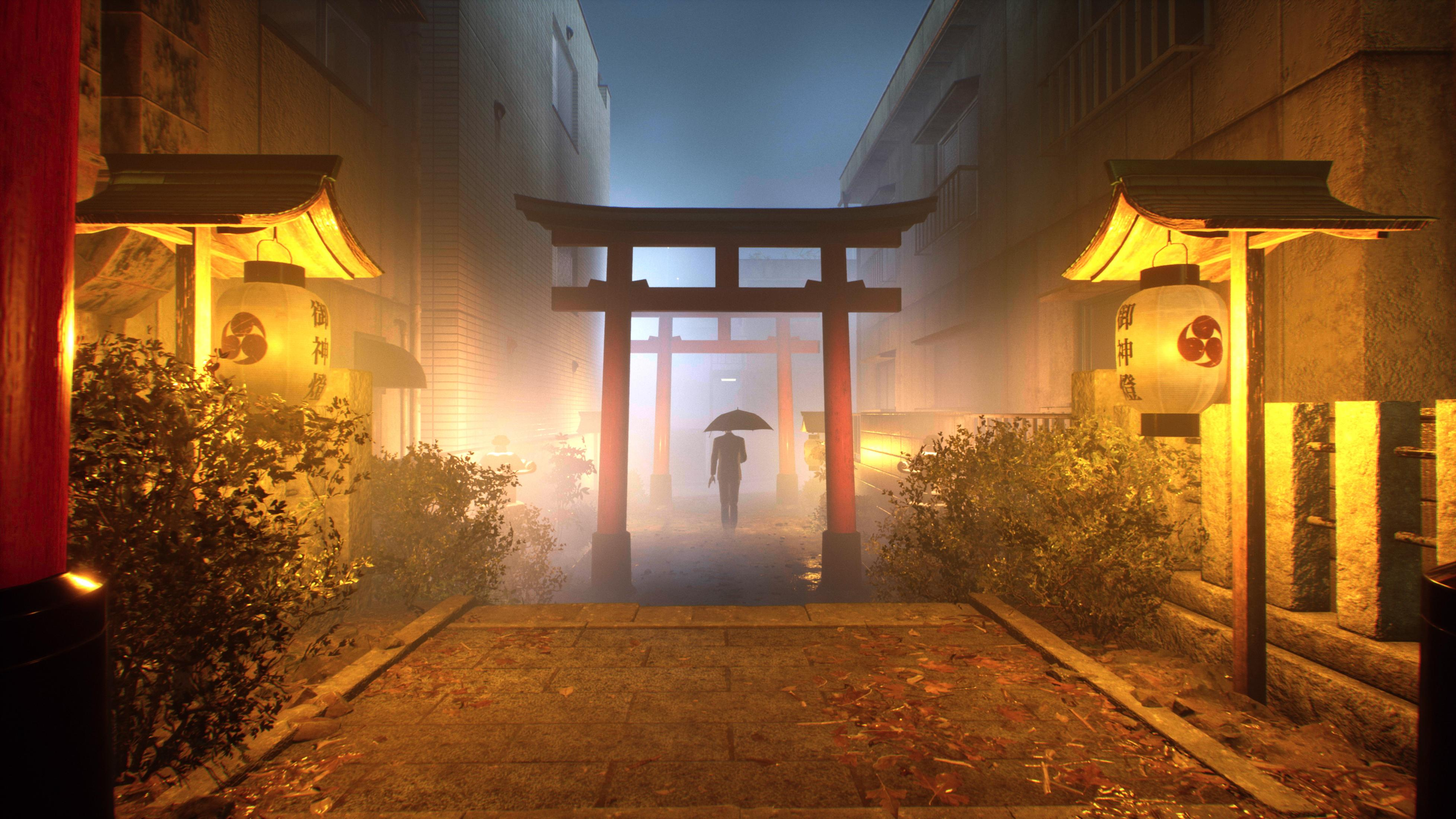 Una persona con ombrello cammina attraverso un cancello torii, illuminato da lanterne.