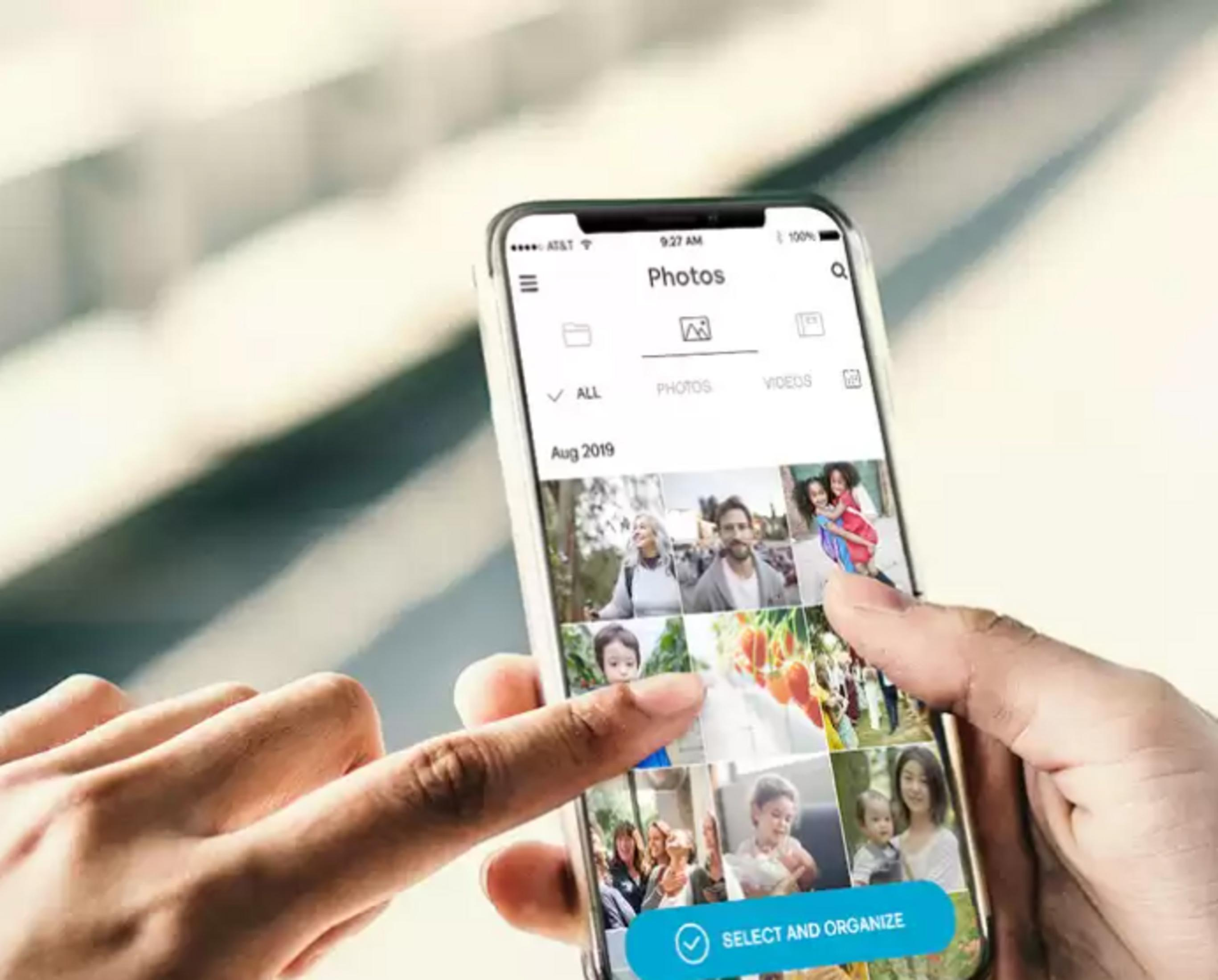 Eine Hand hält ein Smartphone mit einer Fotogalerie.