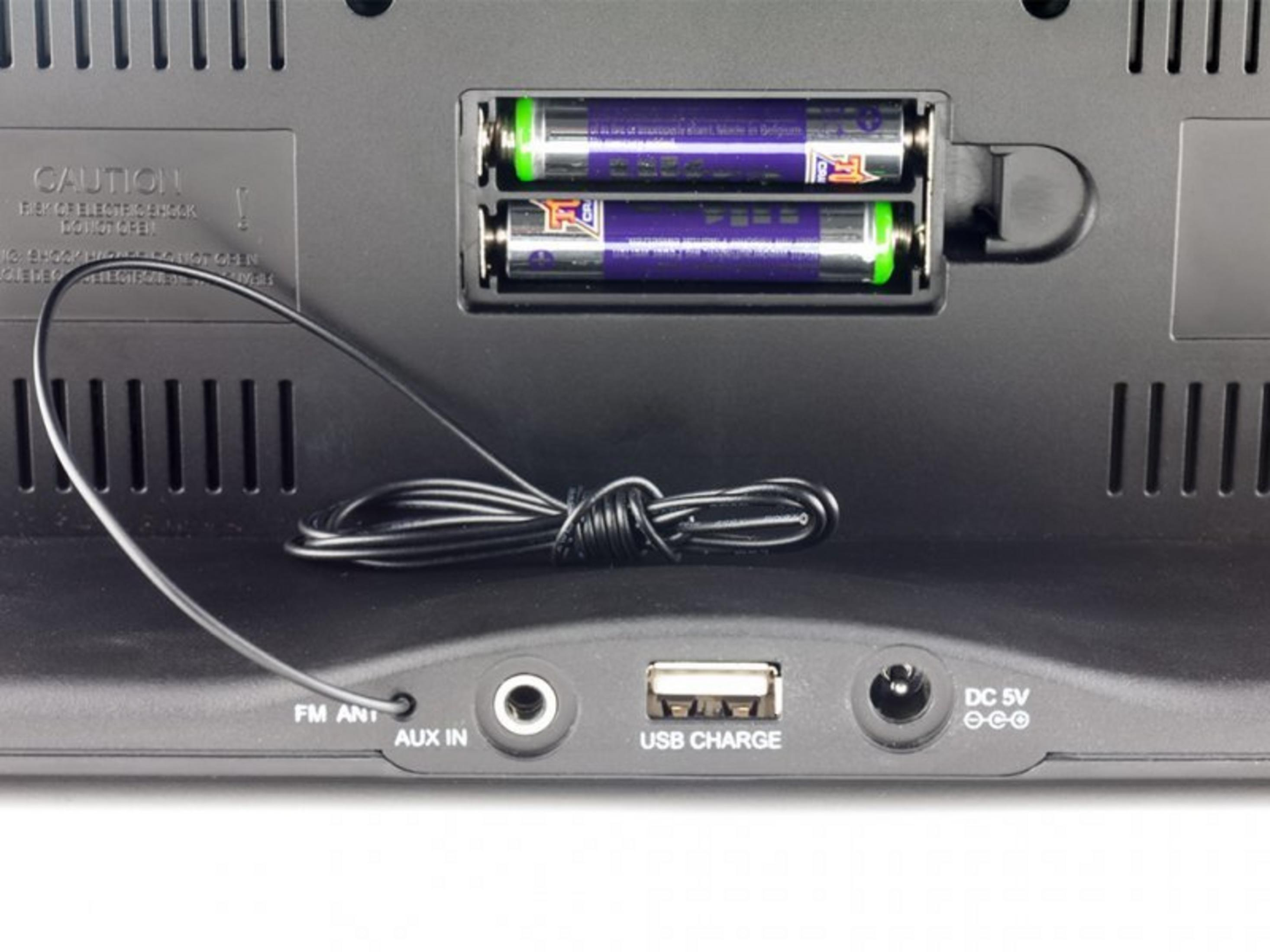 Back of device with battery compartment, AUX input, USB port, and DC power input.