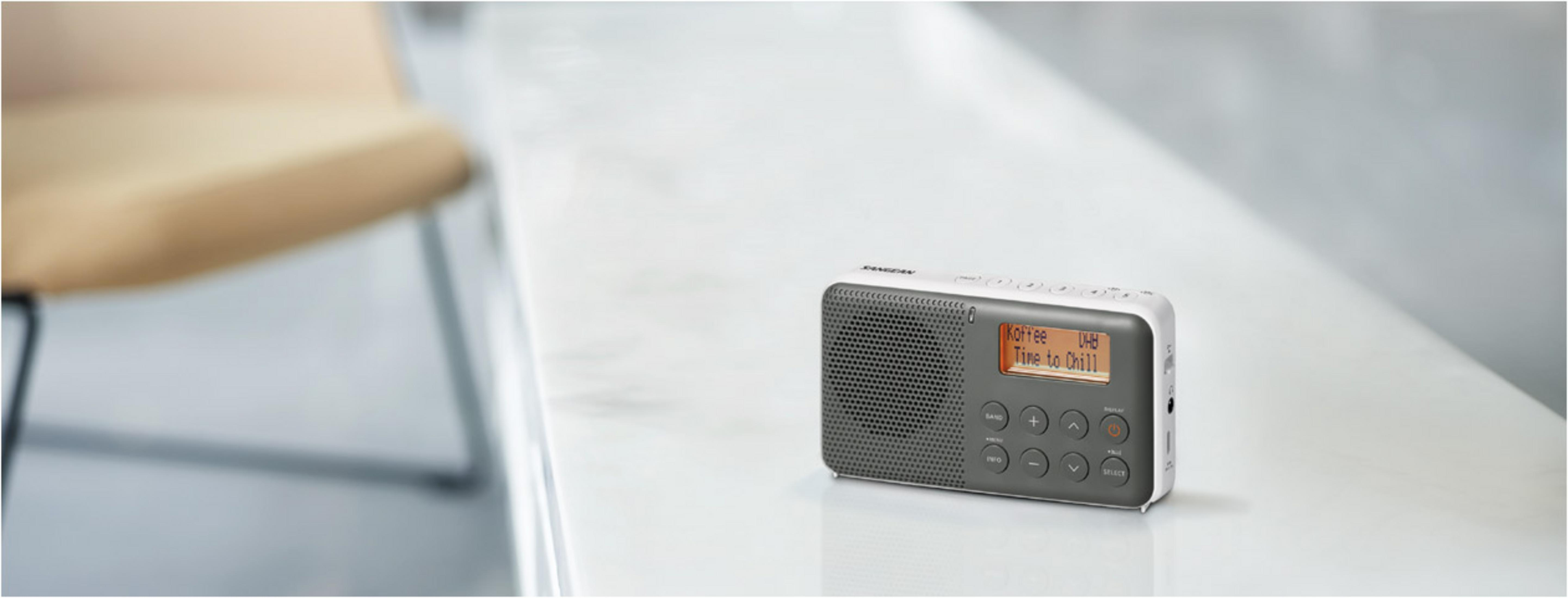 Kompaktowe cyfrowe radio DAB na białej powierzchni.