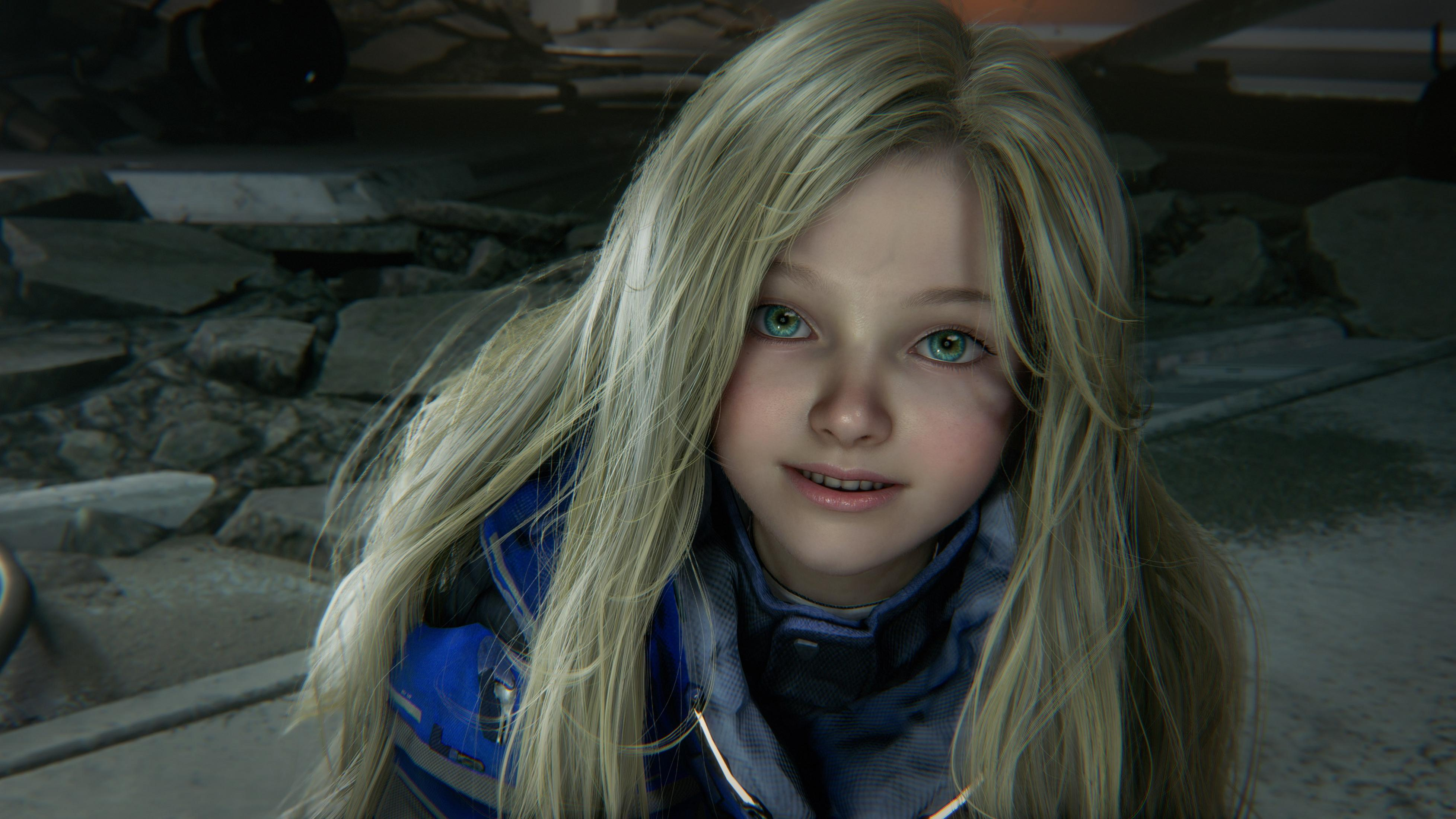 Ein junges Mädchen mit blonden Haaren und blauen Augen trägt eine blaue Jacke.