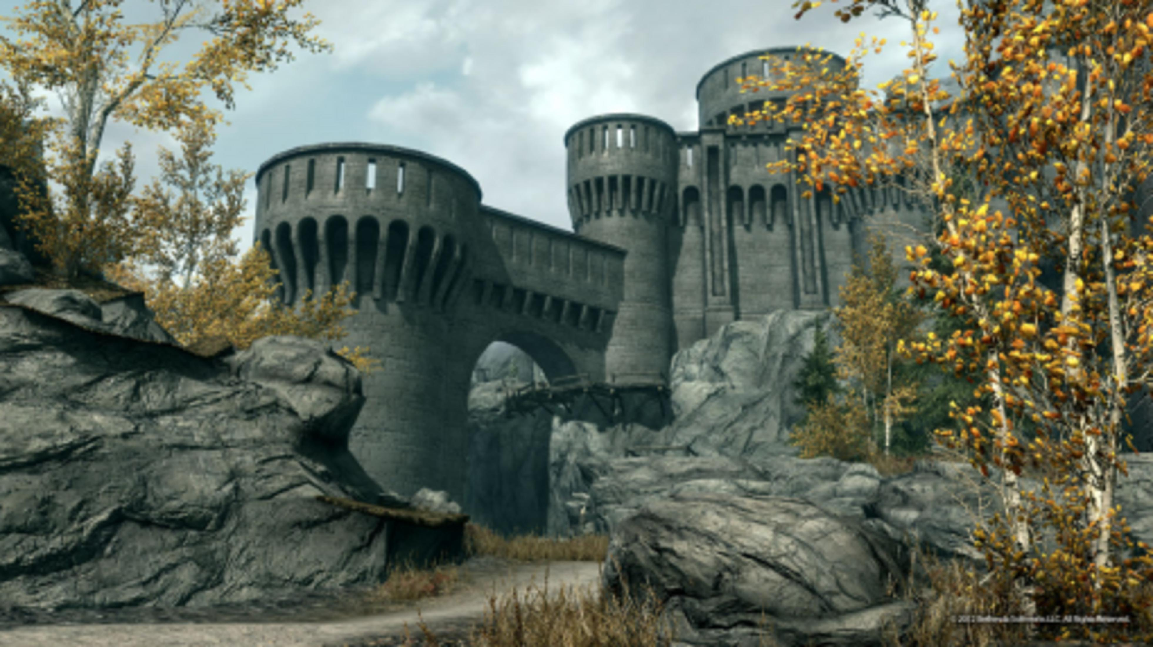 Eine Burg mit runden Türmen und einer Brücke, umgeben von Felsen und Herbstbäumen.