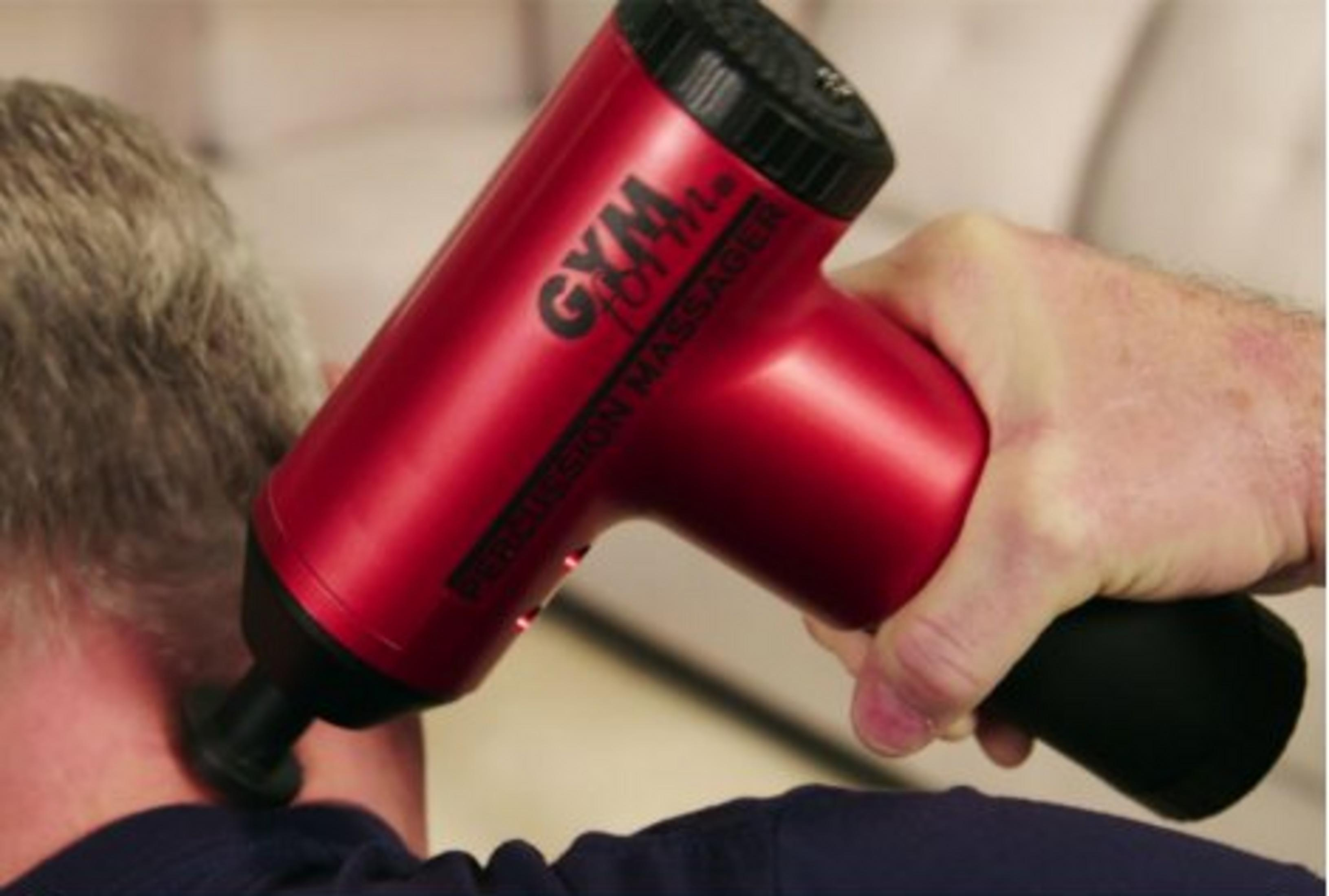 Un pistolet de massage rouge est utilisé sur le cou d'une personne.