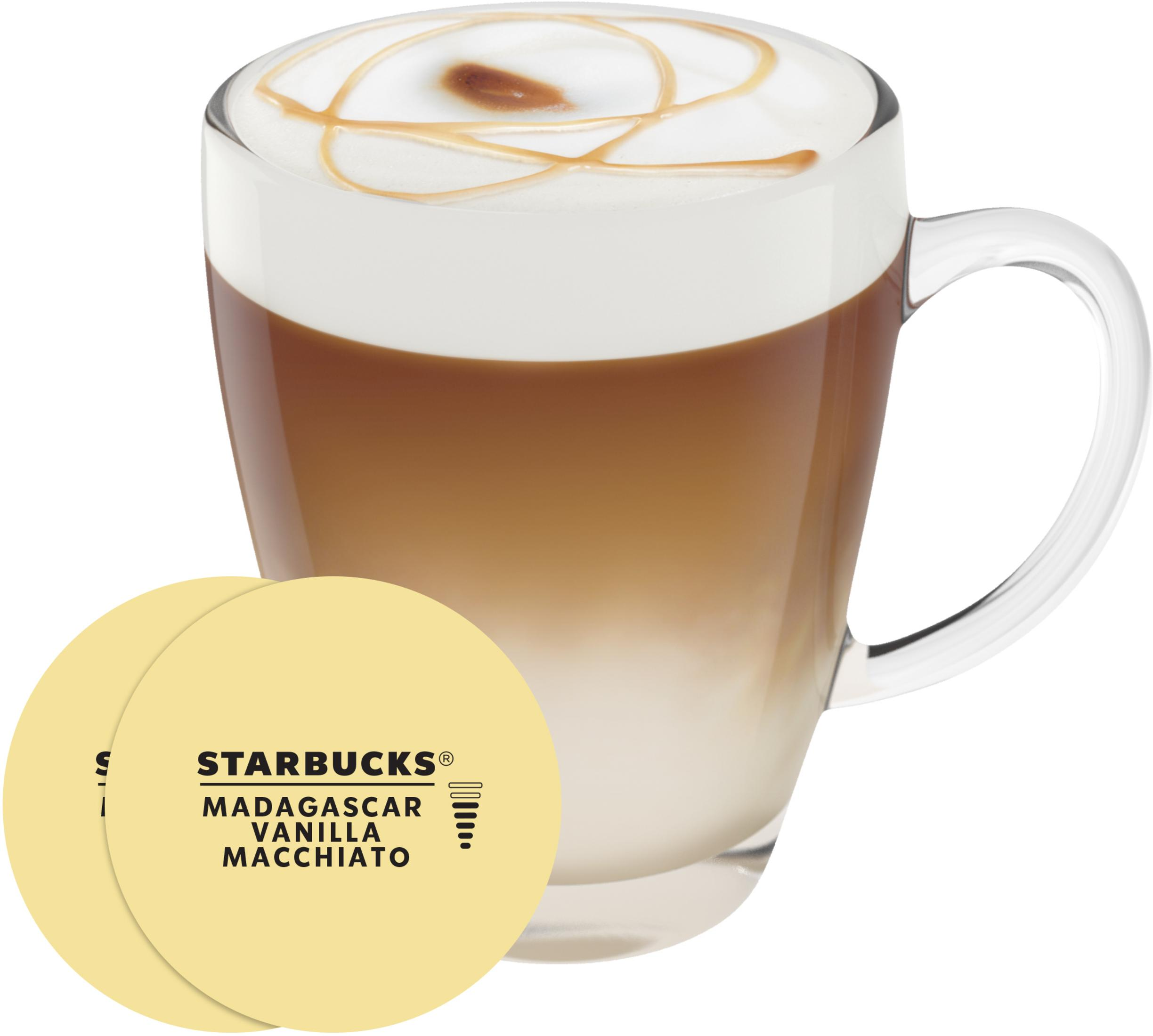 Ein Glas Macchiato mit Karamell-Topping und zwei gelben Starbucks-Aufklebern daneben.