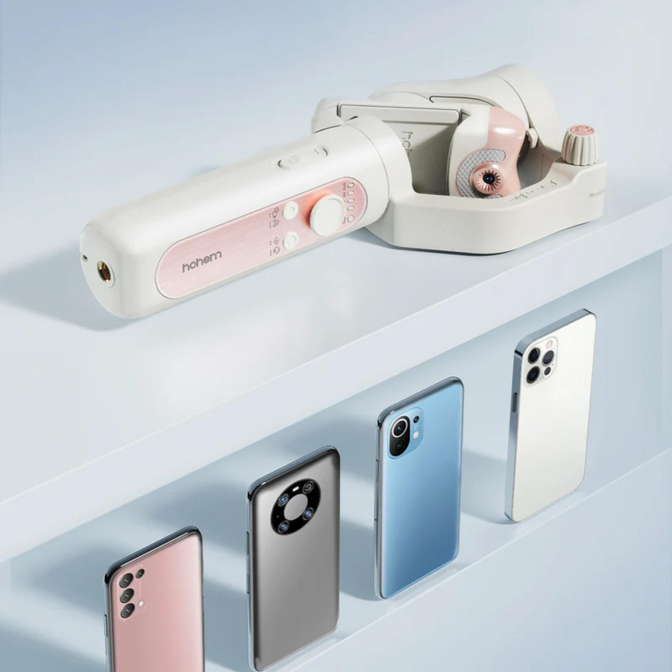 Biały gimbal spoczywa na półce nad czterema smartfonami w kolorze różowym, srebrnym, niebieskim i białym.