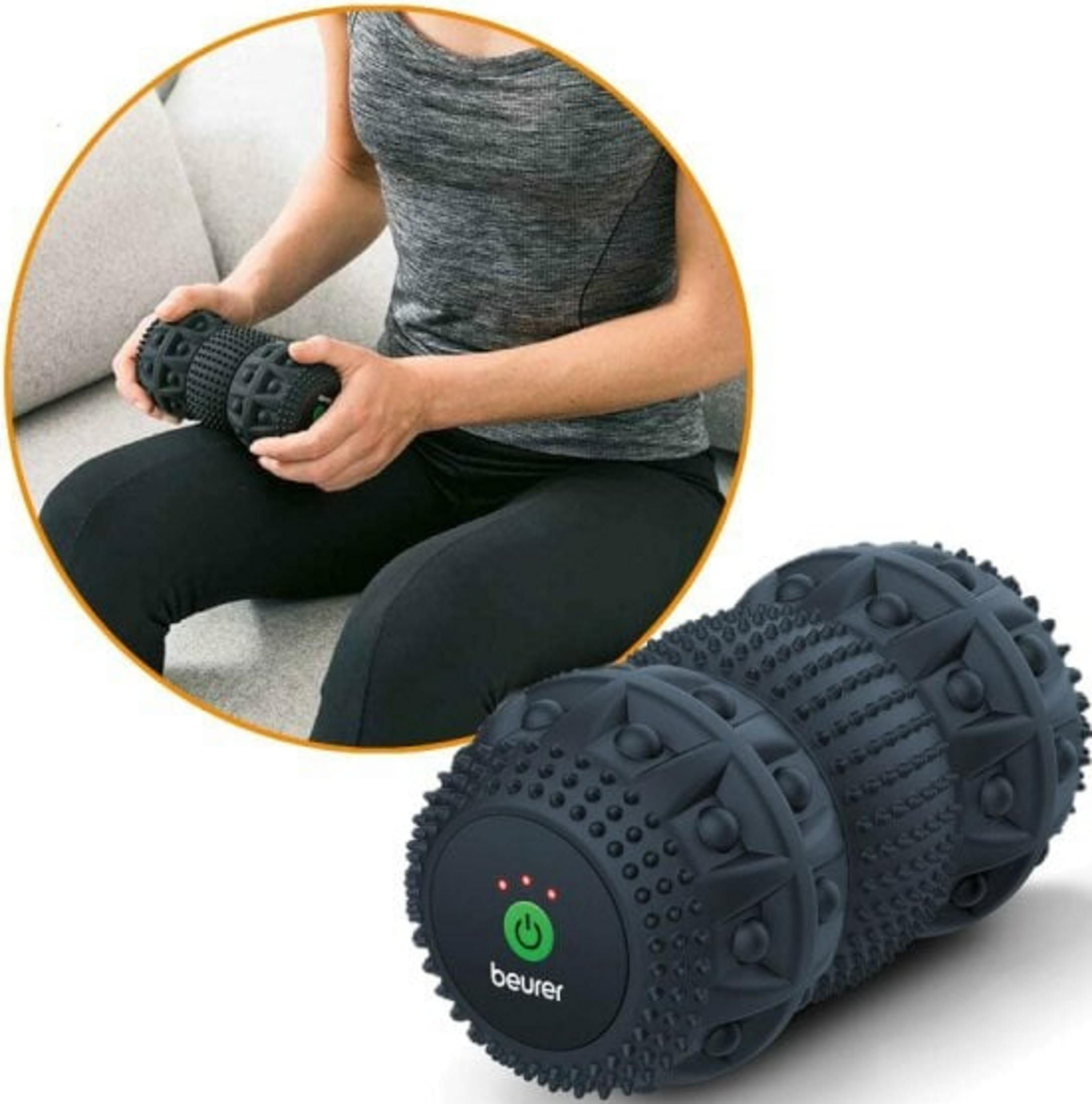 Eine Person benutzt eine schwarze Massage-Rolle auf ihrem Bein.