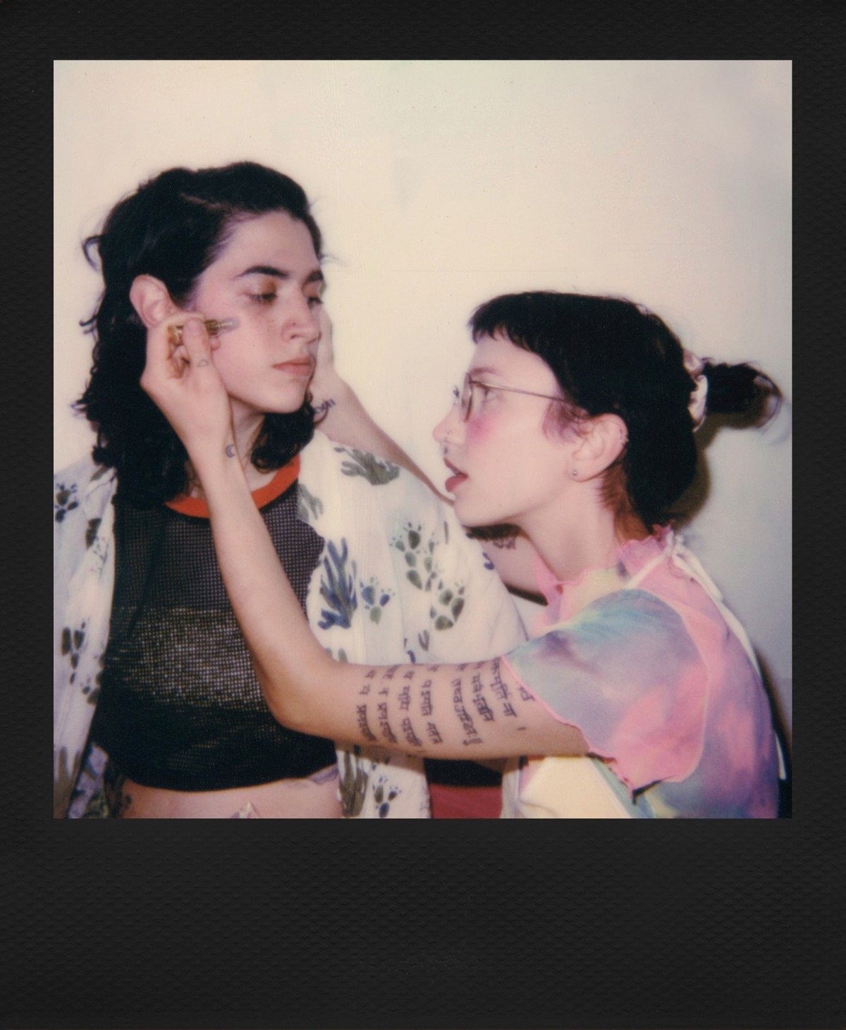 Jedna osoba maluje twarz drugiej, zbliżenie.