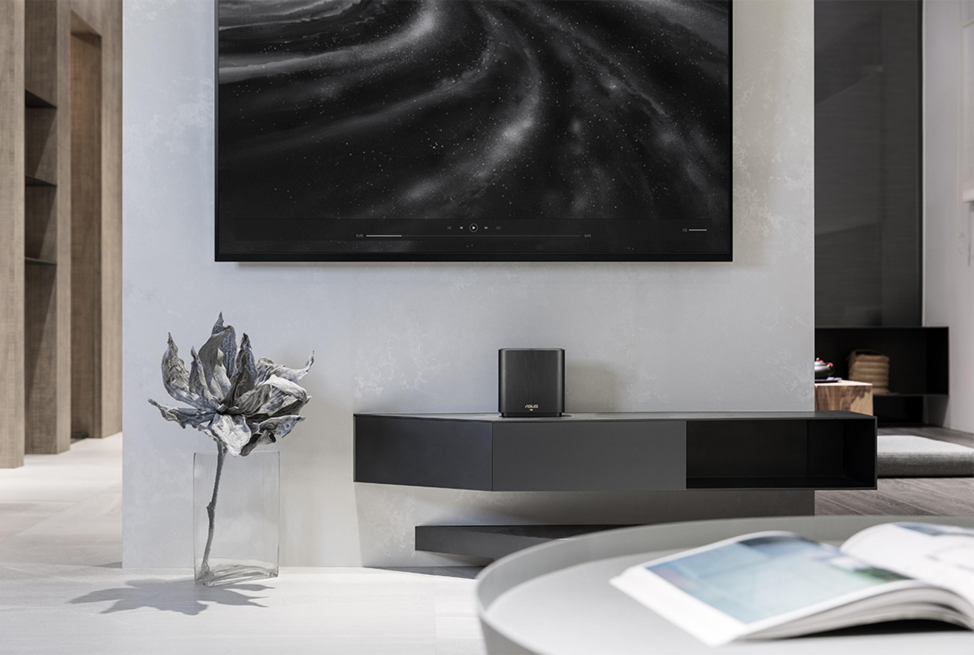 Nowoczesny salon z telewizorem, półką, dekoracyjnym kwiatem i stolikiem.