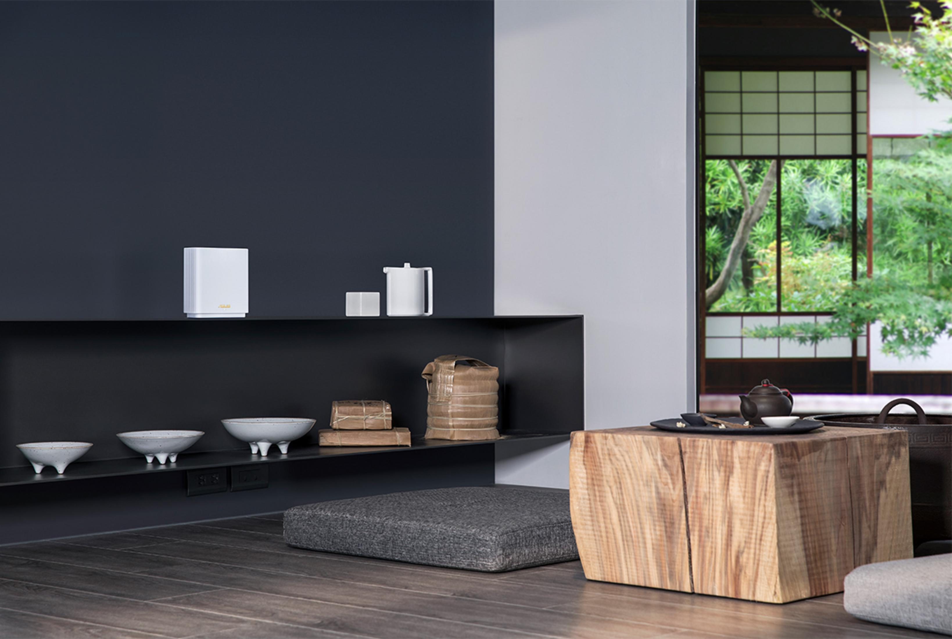 Nowoczesny salon z półkami, ceramicznymi misami, drewnianym stołem i widokiem na ogród.