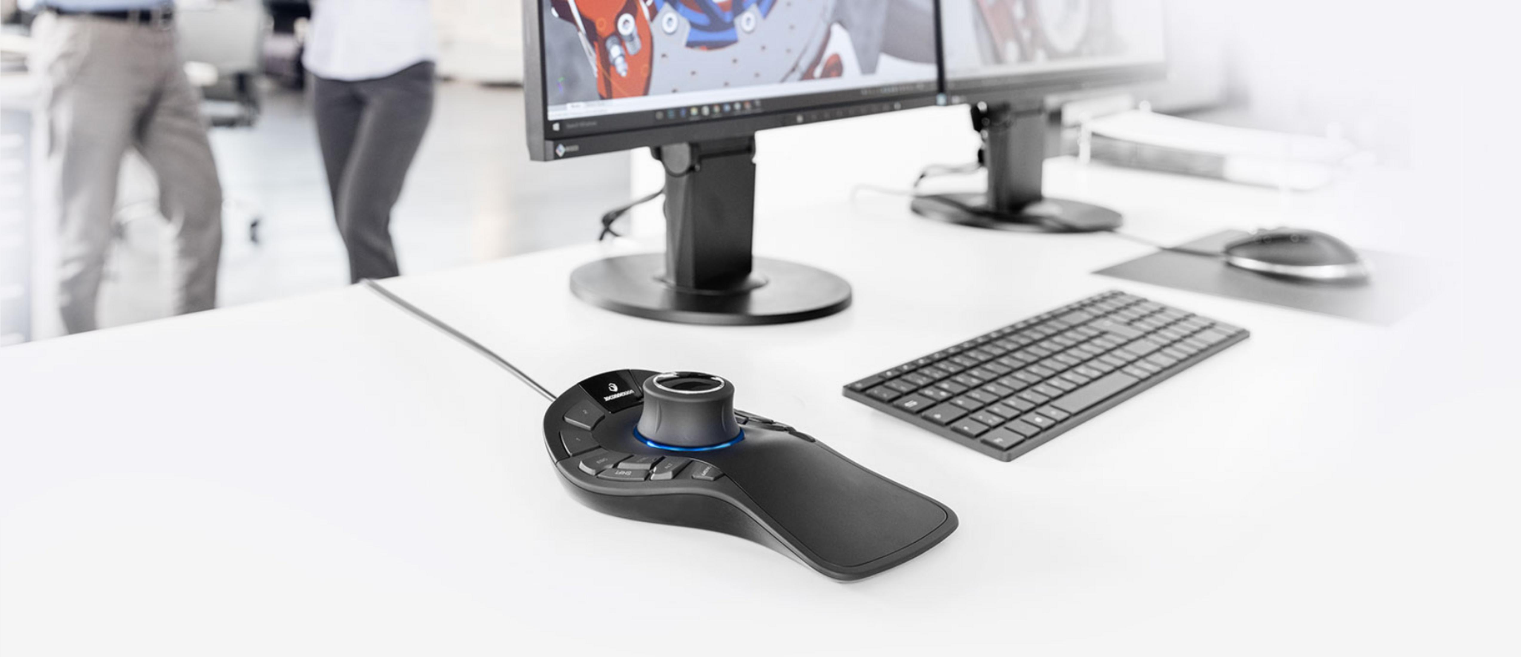 Ein schwarzer 3D-Maus auf einem weißen Schreibtisch mit Tastatur und Monitor.