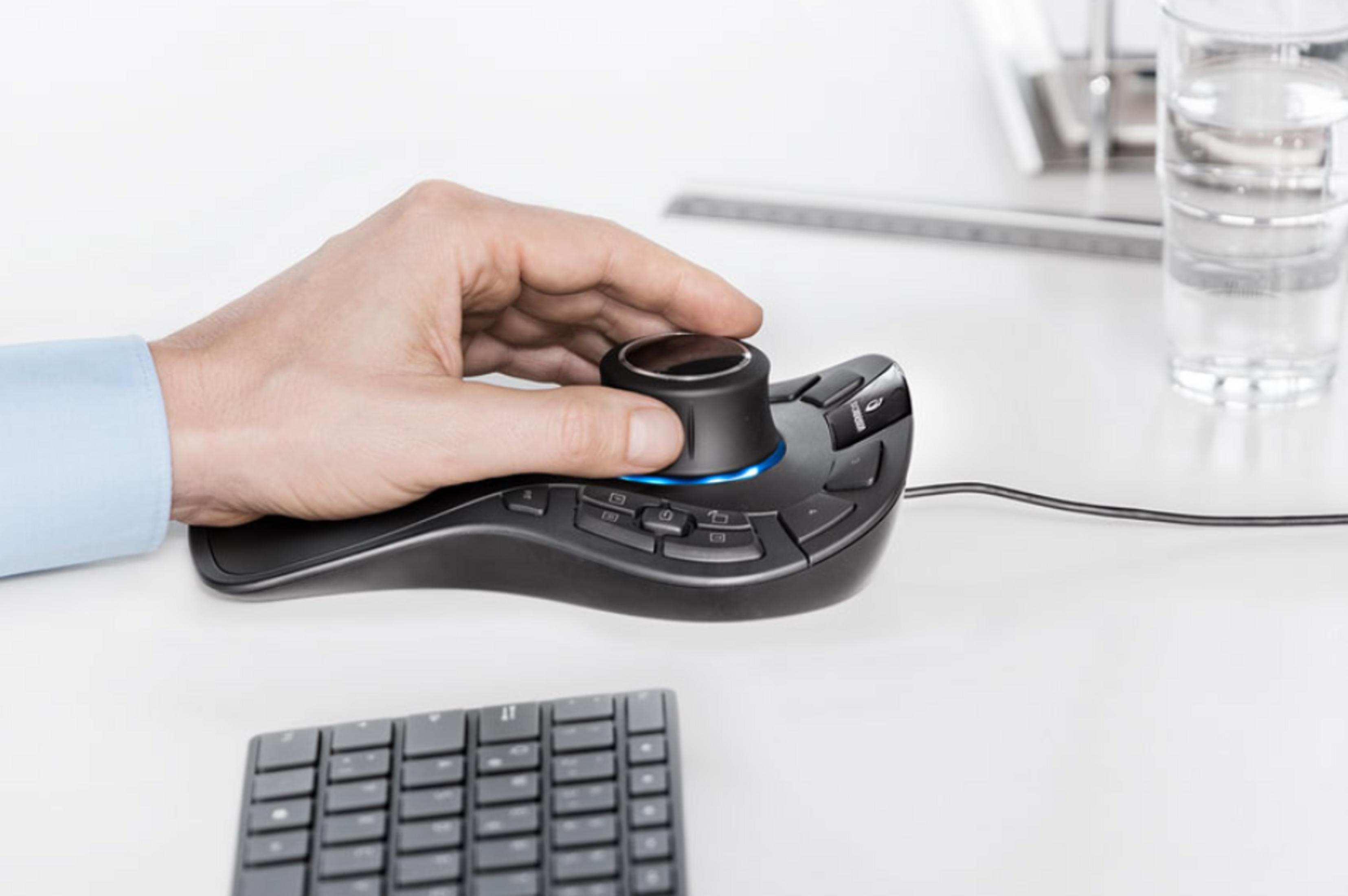 Ein Mann benutzt eine schwarze 3D-Maus mit einem blauen Lichtring. Eine Tastatur liegt daneben.