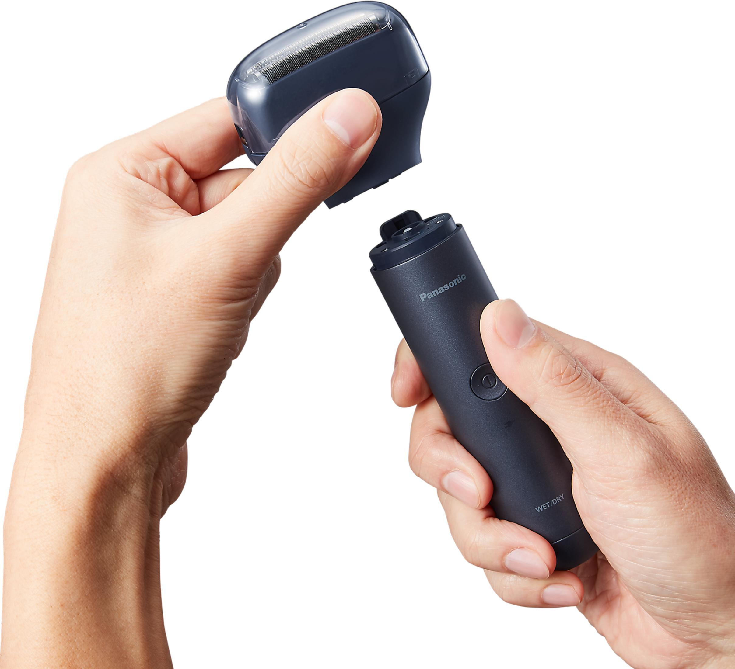 Dłonie składają ciemną maszynkę do golenia Panasonic ze srebrnym ostrzem.
