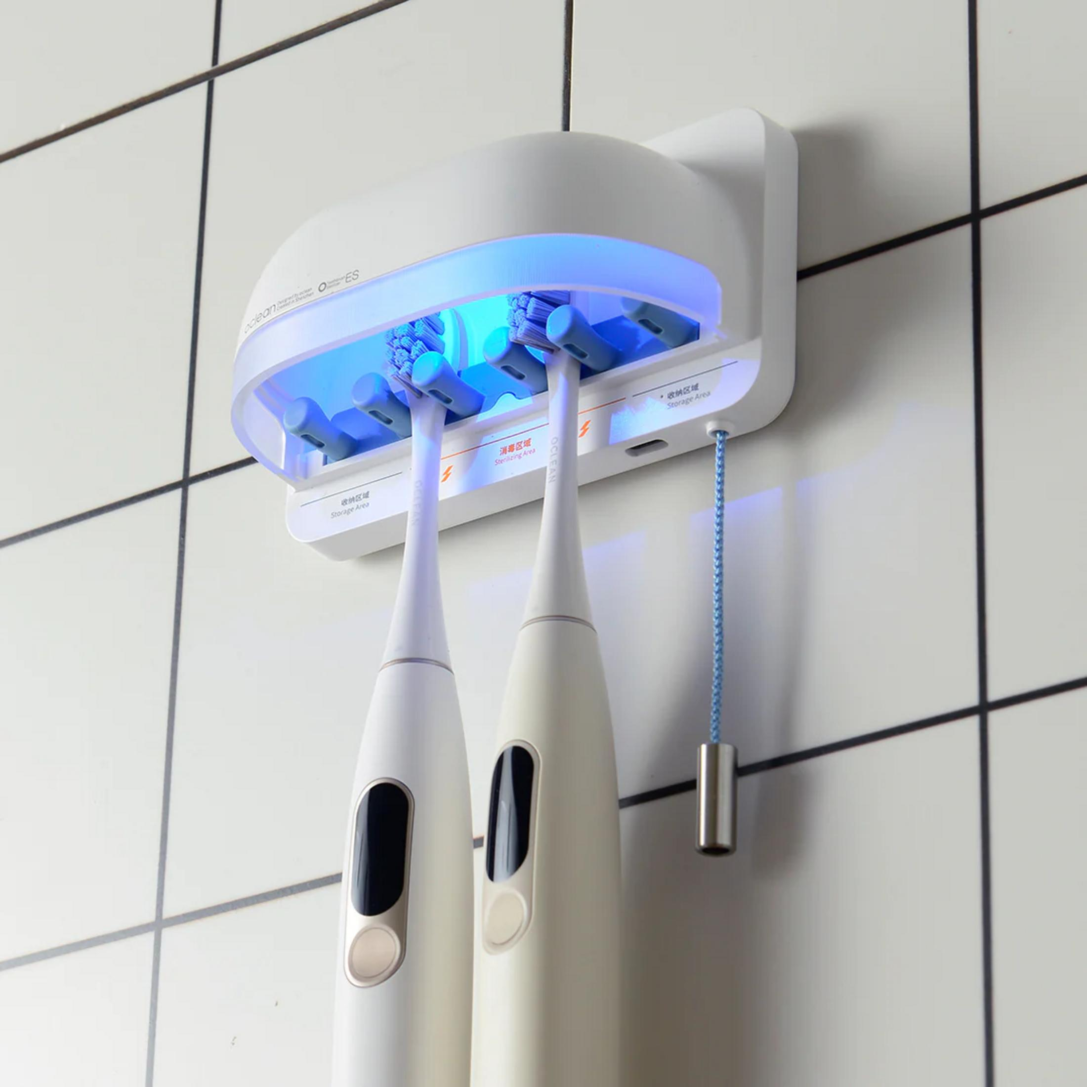 Un soporte blanco para cepillos de dientes con luces UV azules.