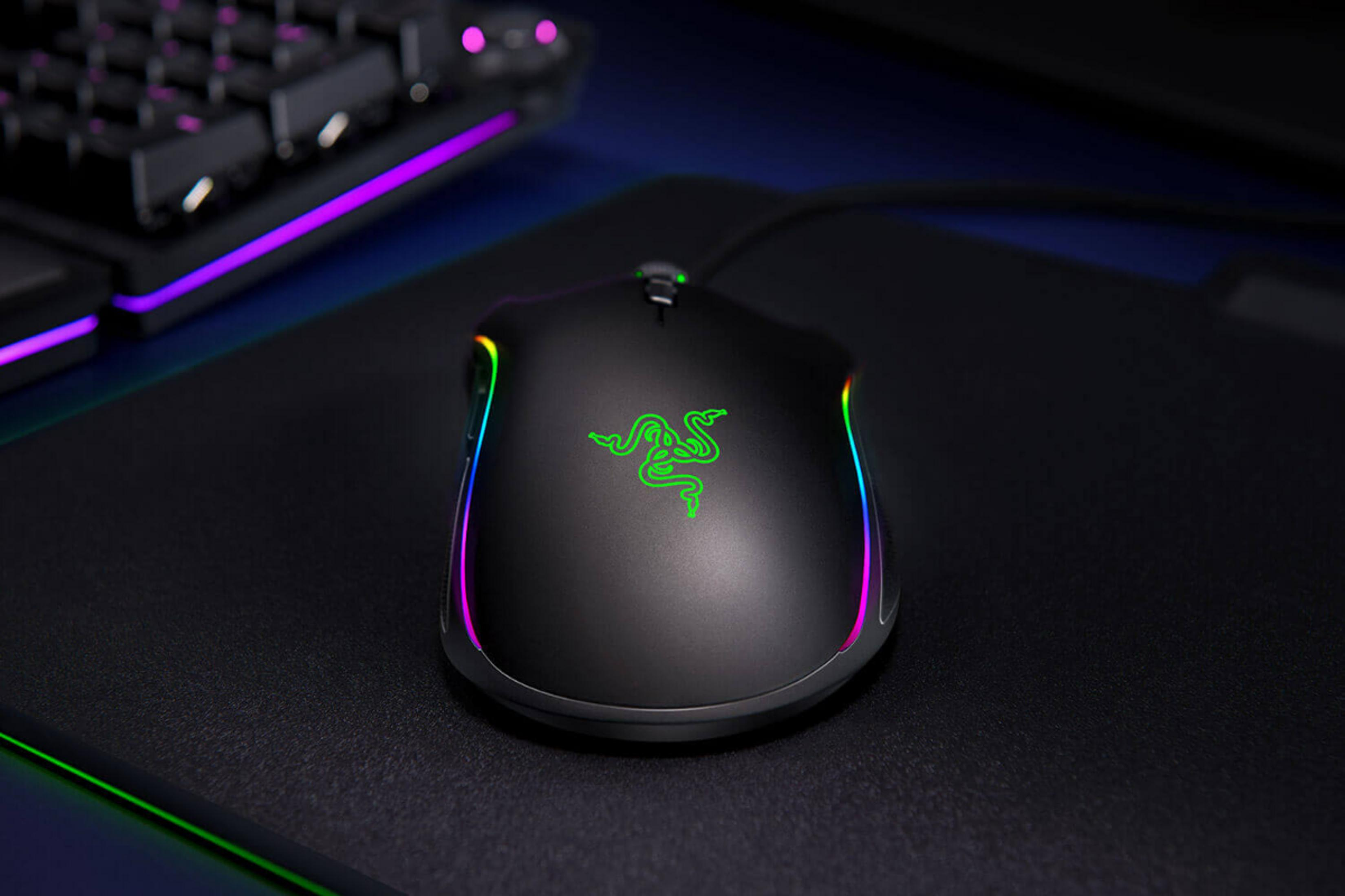 Schwarze Gaming-Maus mit grünem Logo und RGB-Beleuchtung auf schwarzer Matte.