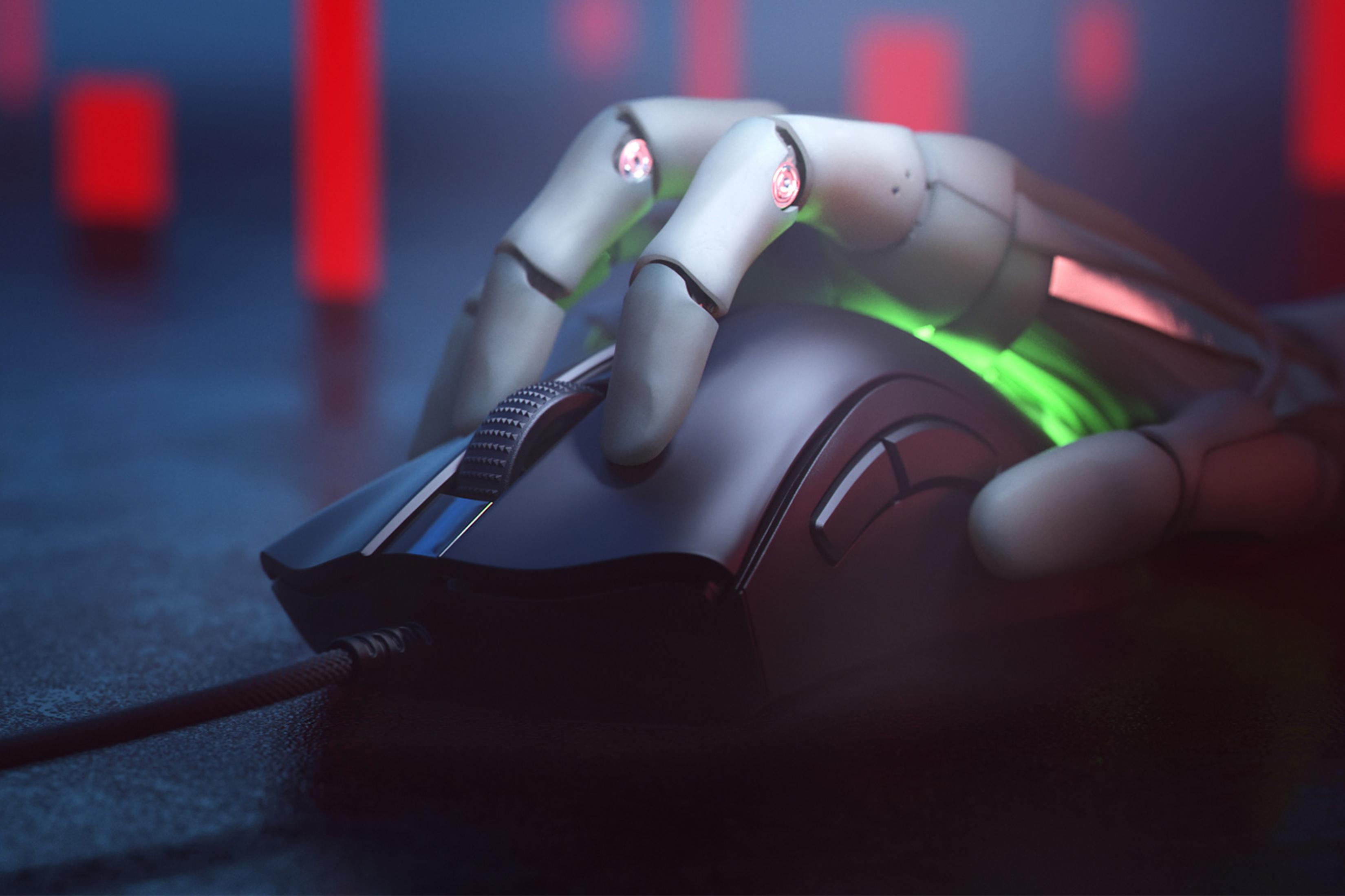 Ein Roboterfinger ruht auf einer schwarzen Maus mit grüner Beleuchtung.
