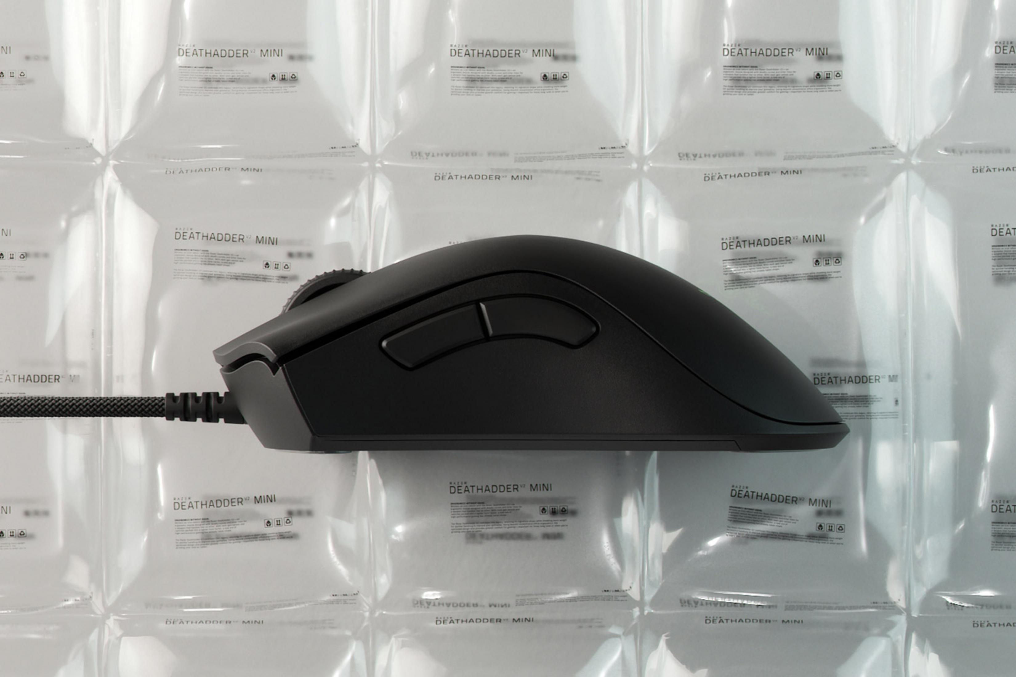 Schwarze Computermaus mit Kabel auf verpacktem Hintergrund.