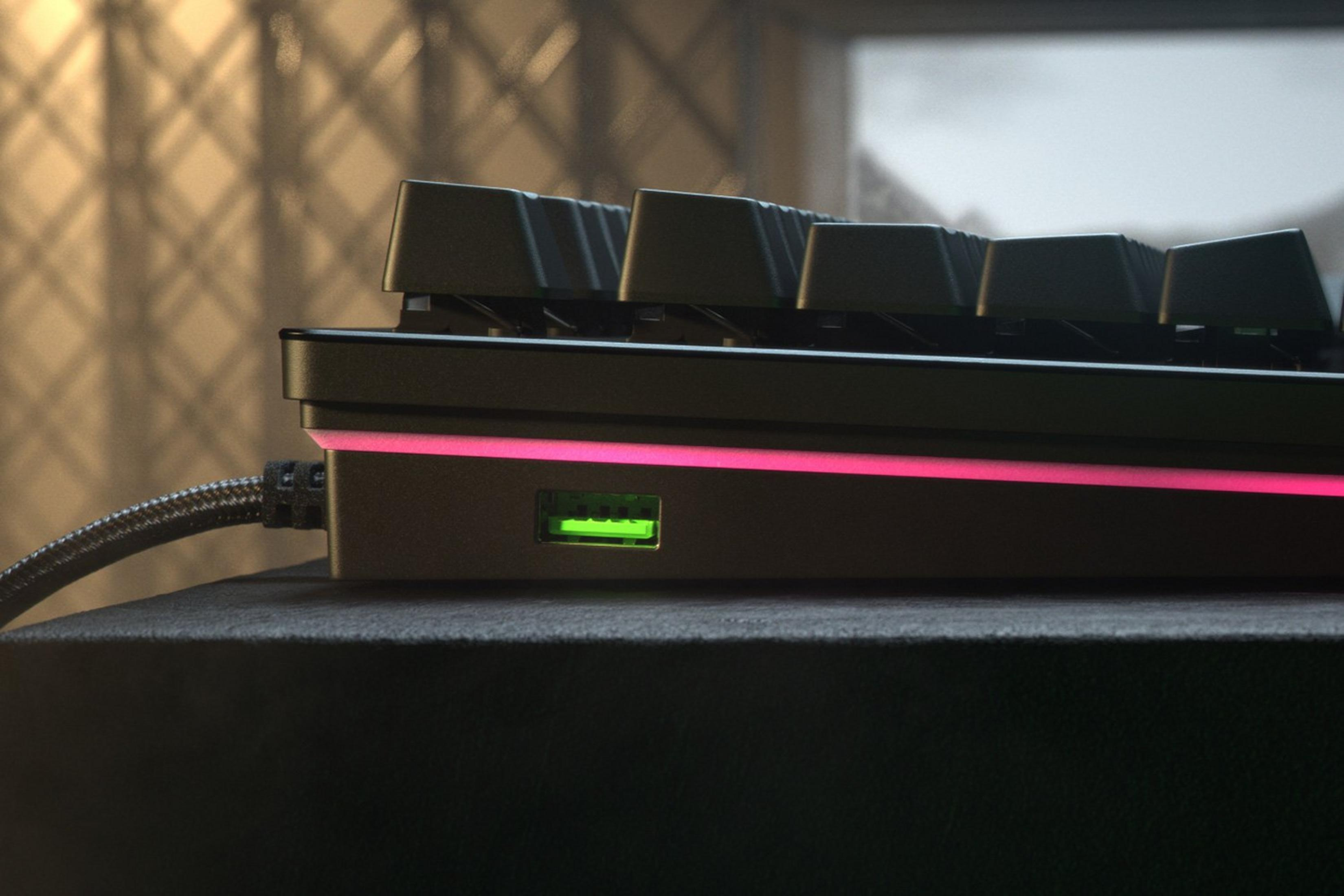 Schwarze Tastatur mit pinker LED-Beleuchtung und einem grünen USB-Anschluss.