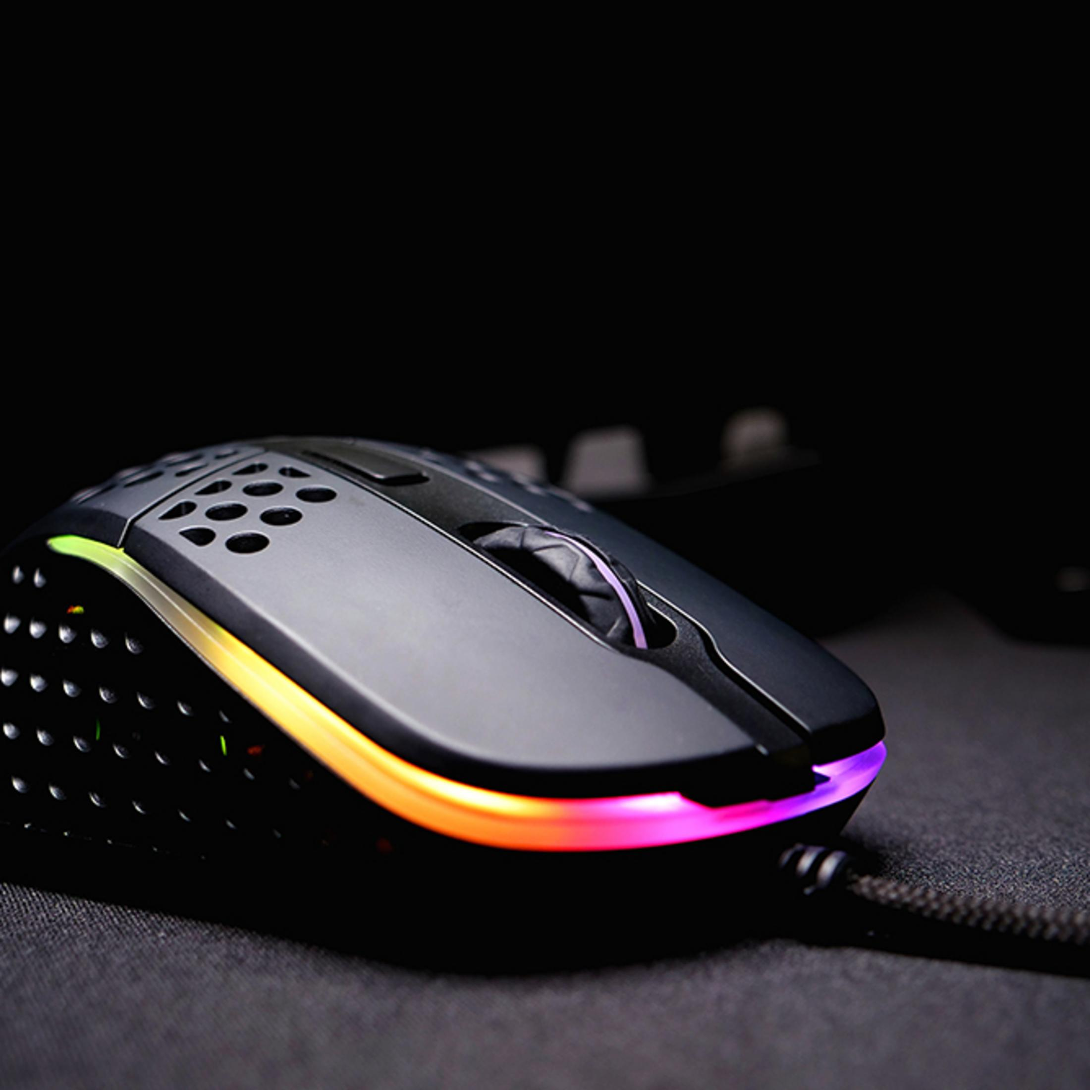 Mouse da gaming nero con illuminazione RGB su superficie nera.