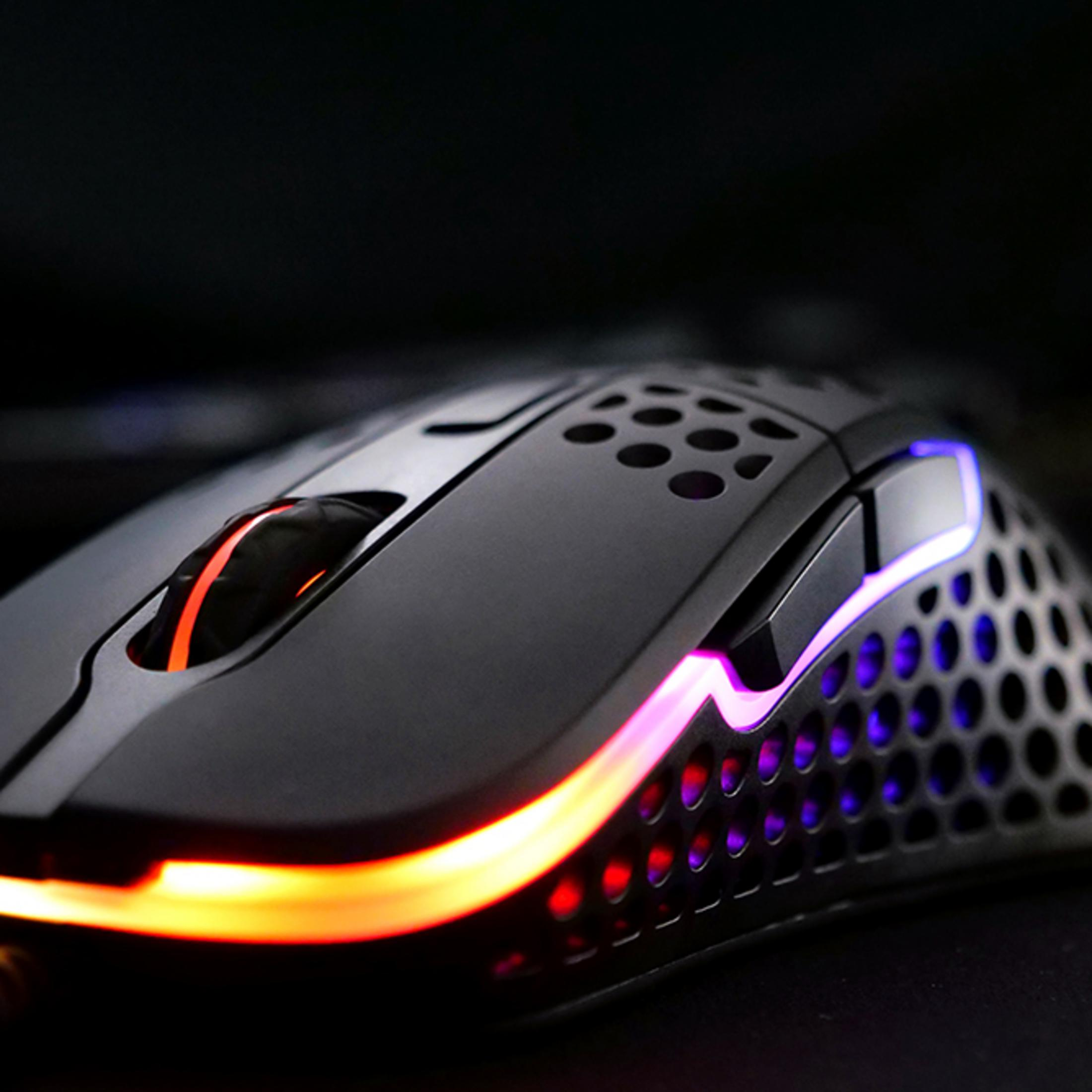 Un mouse da gaming nero con illuminazione RGB. Luci arancioni e viola brillano.