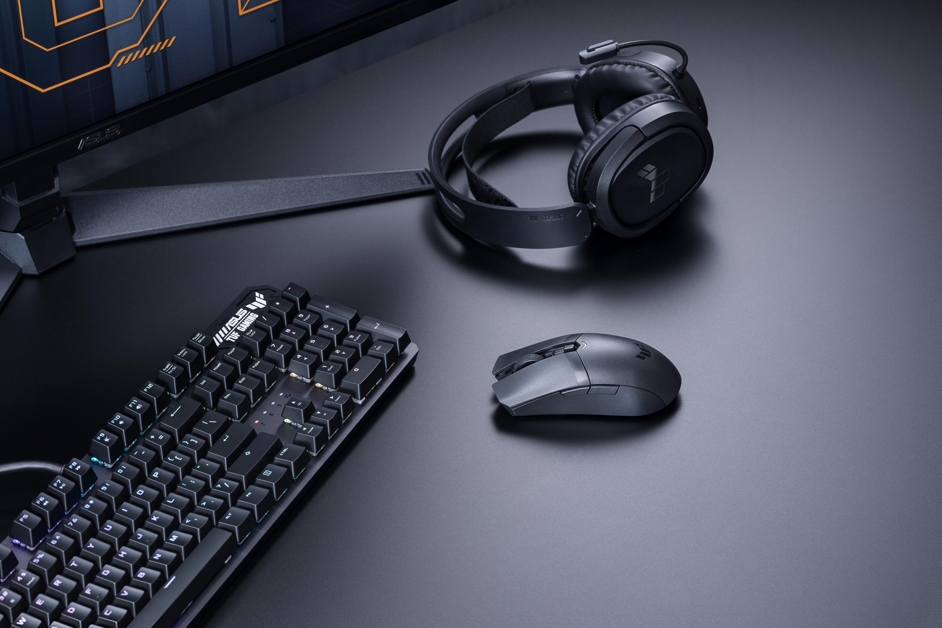 Czarna klawiatura, mysz i słuchawki gamingowe na ciemnym biurku.