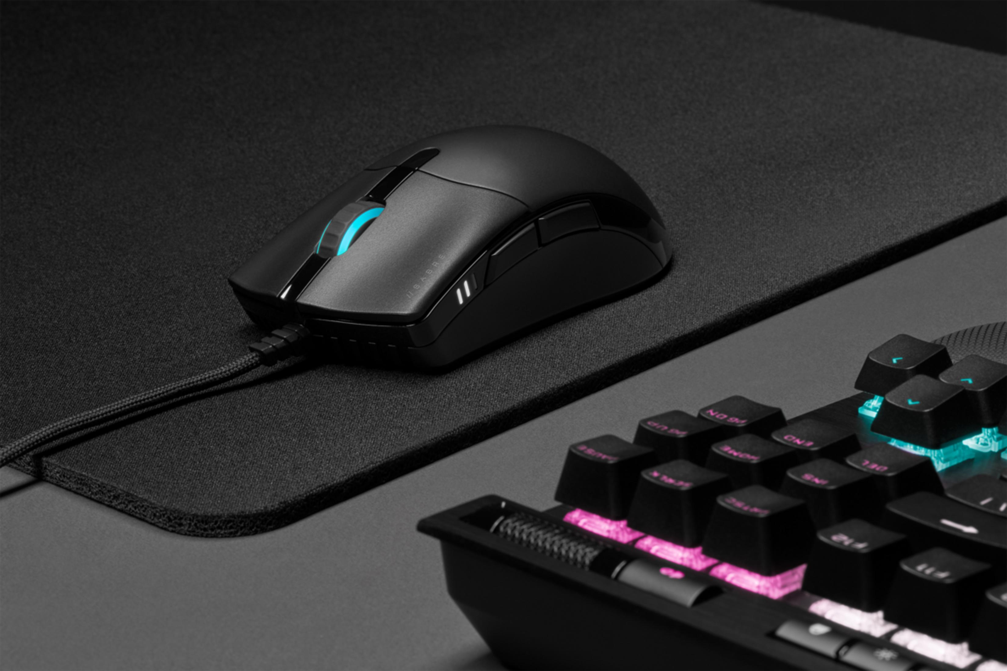 Een zwarte gamingmuis met blauw scrollwiel op een zwart toetsenbord met RGB-verlichting.