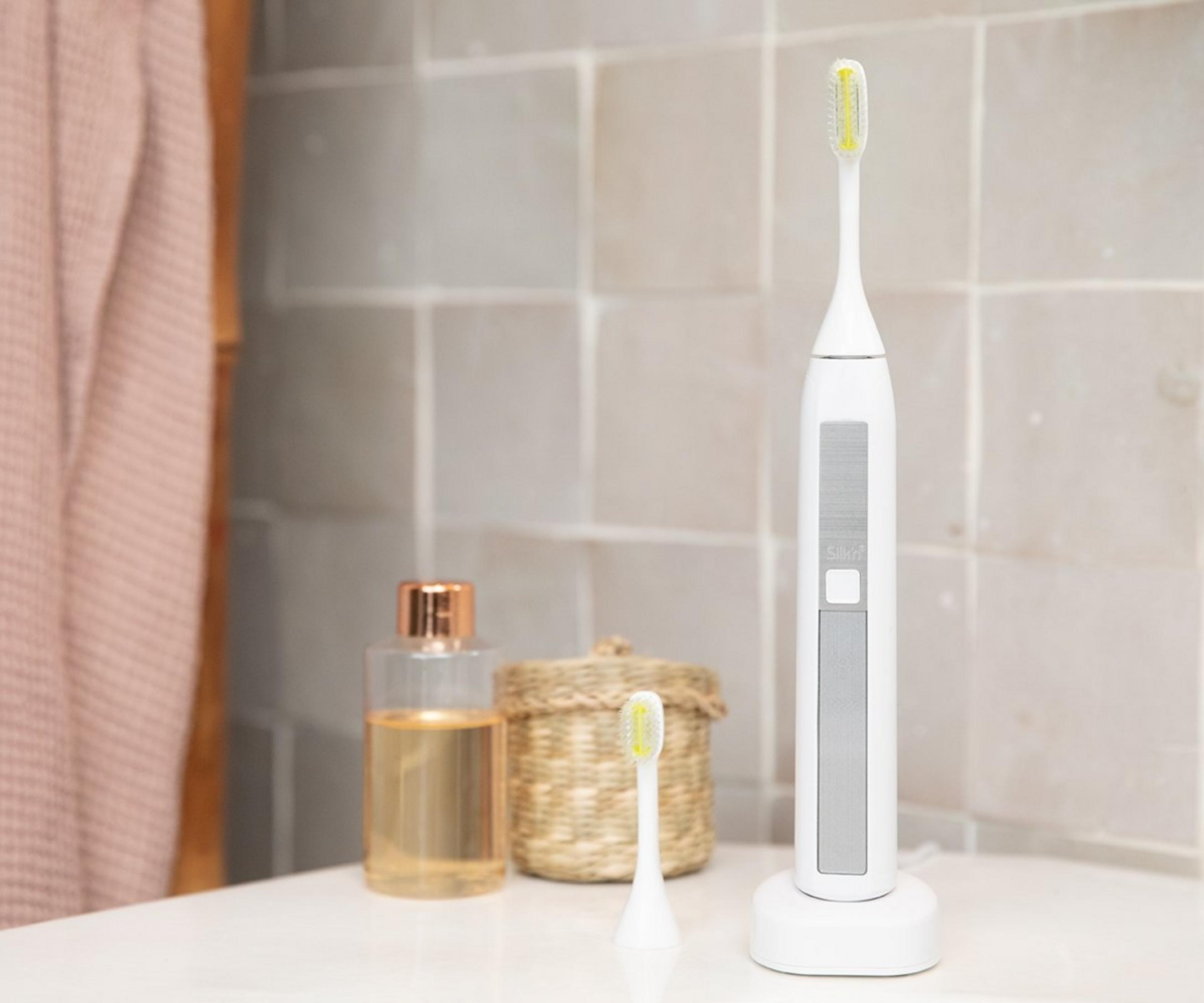 Un set de brosse à dents électrique blanc avec des bouteilles et un panier.