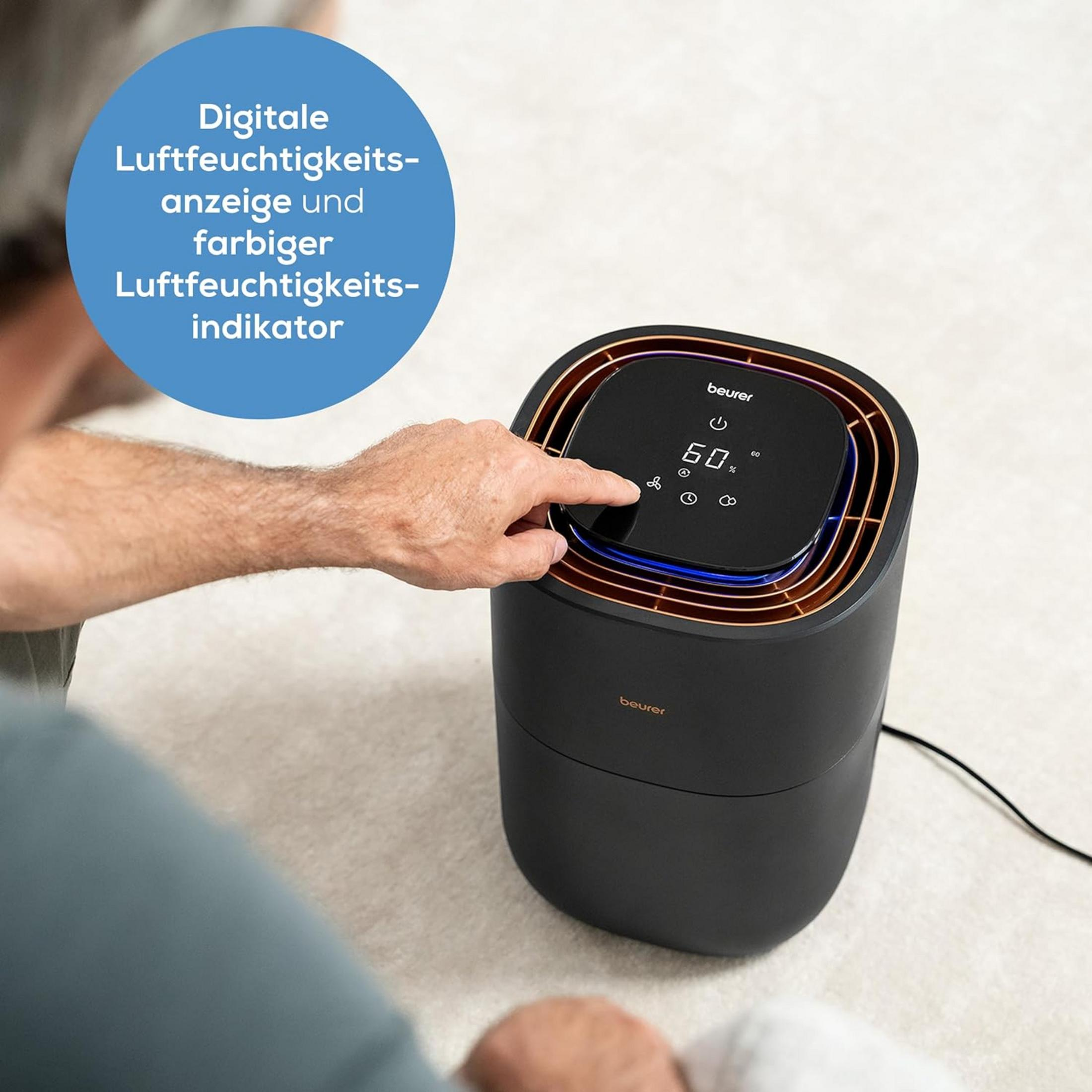 Mann bedient schwarzen Luftentfeuchter mit Display. Anzeige 60%.