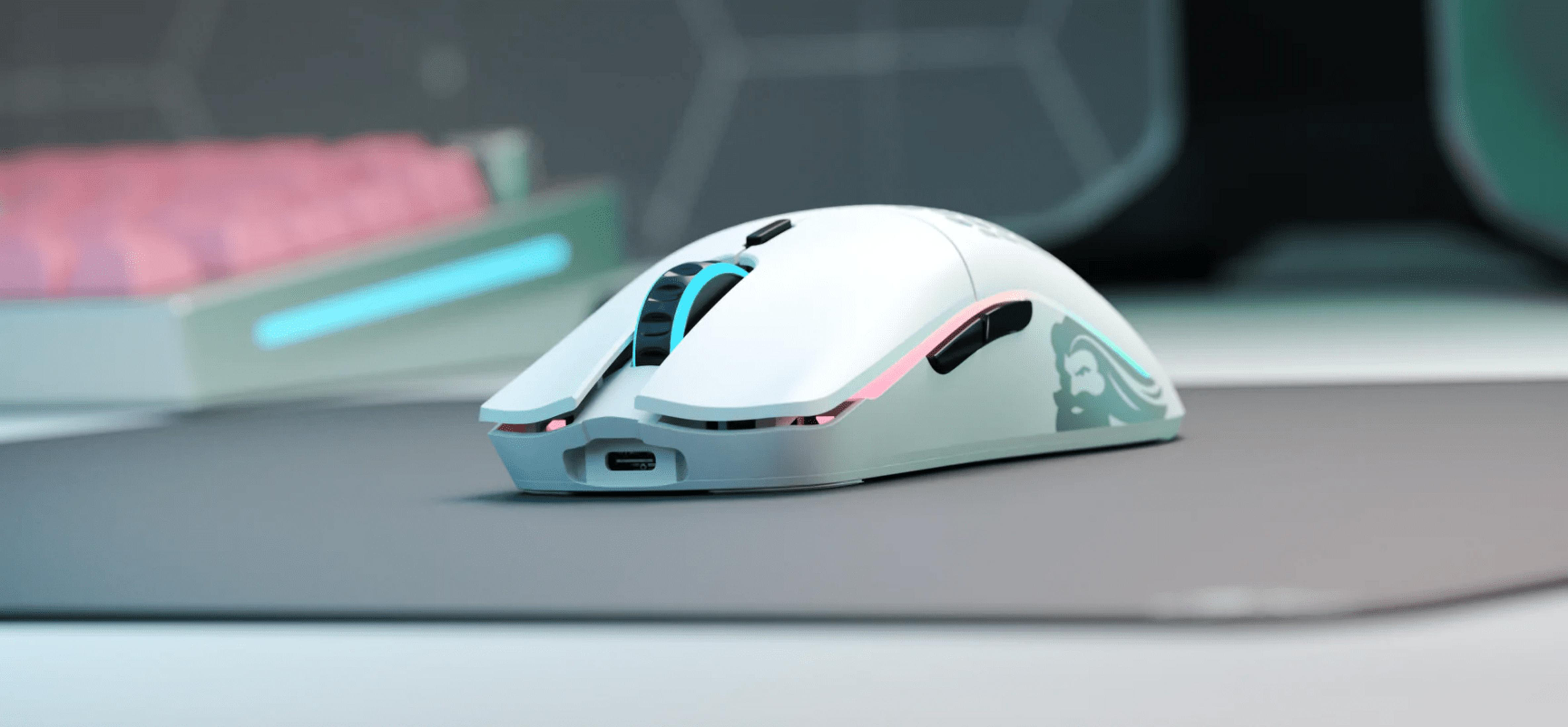 Un mouse da gaming bianco con illuminazione RGB su un tappetino.