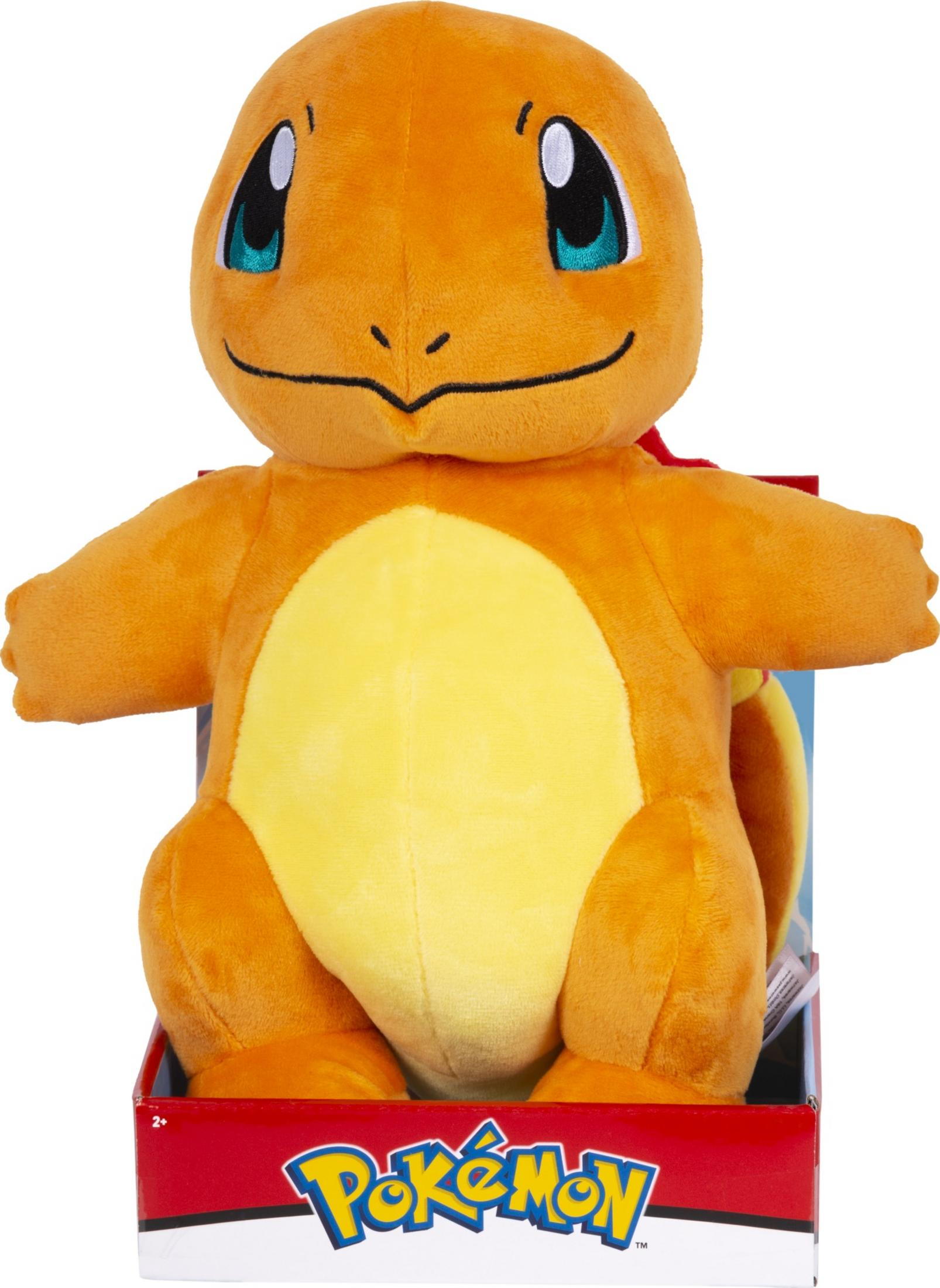 Ein orangefarbener Charmander-Plüsch in einer roten Pokémon-Box.