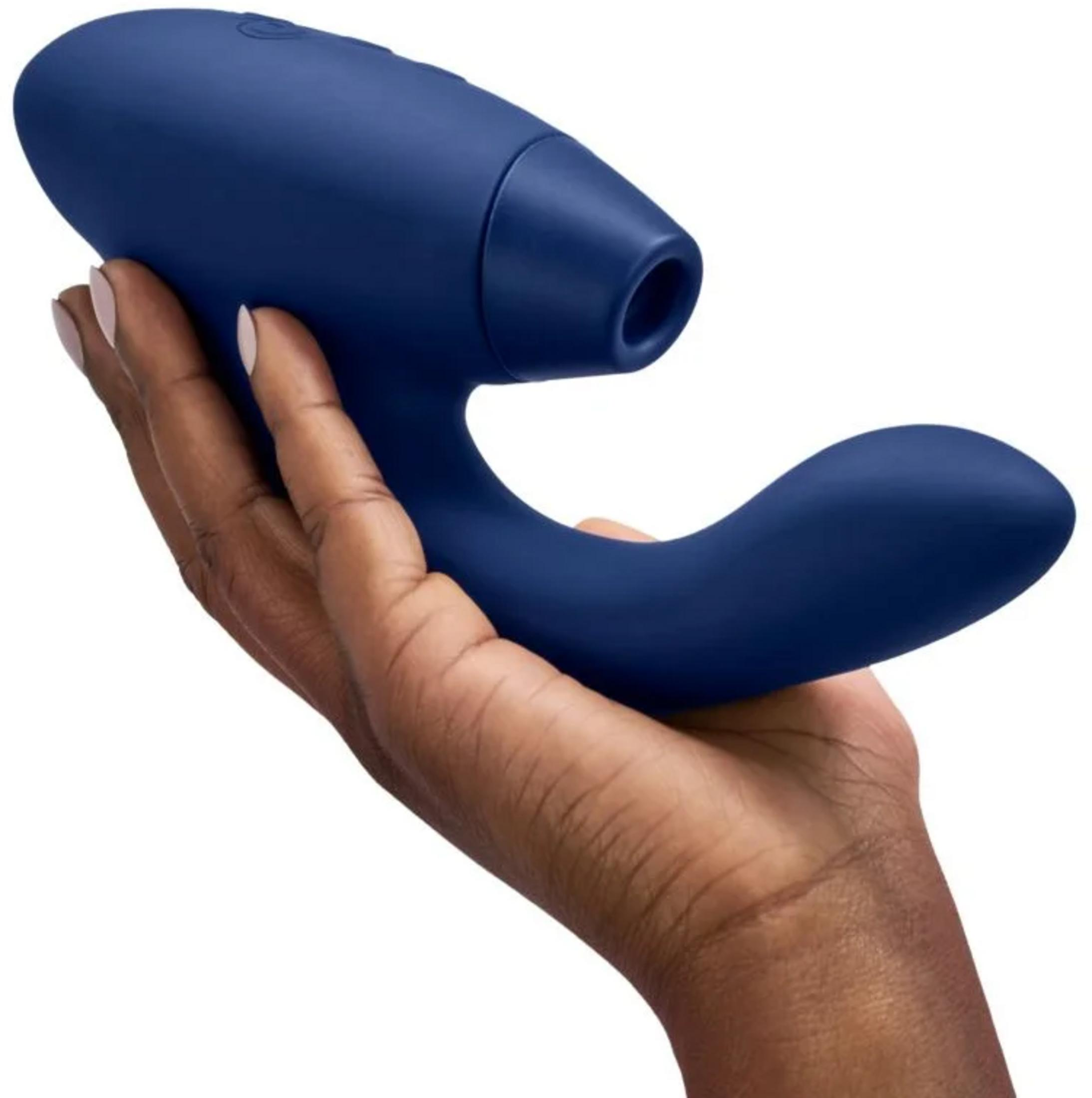 Eine Hand hält einen dunkelblauen, gebogenen Vibrator mit einer runden Spitze.