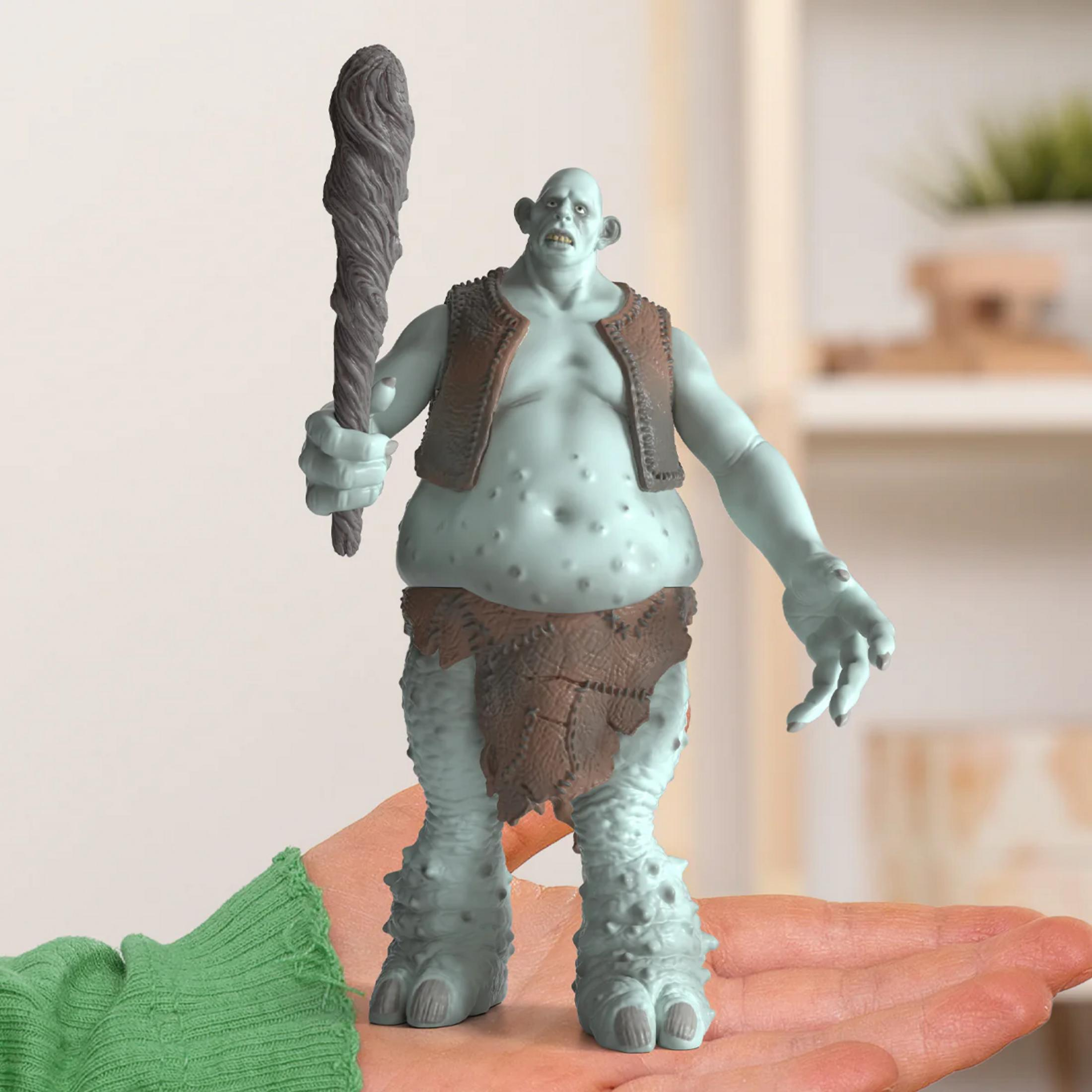 Niebieski troll z maczugą stoi na dłoni. Nosi kamizelkę i przepaskę na biodra.