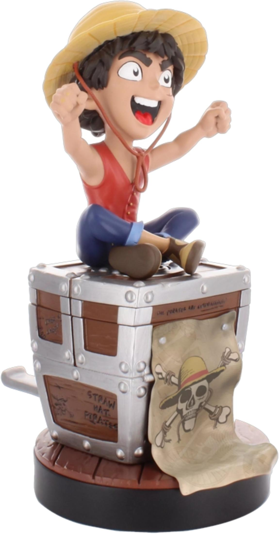 Una figura dei cartoni animati con cappello di paglia siede su un forziere.