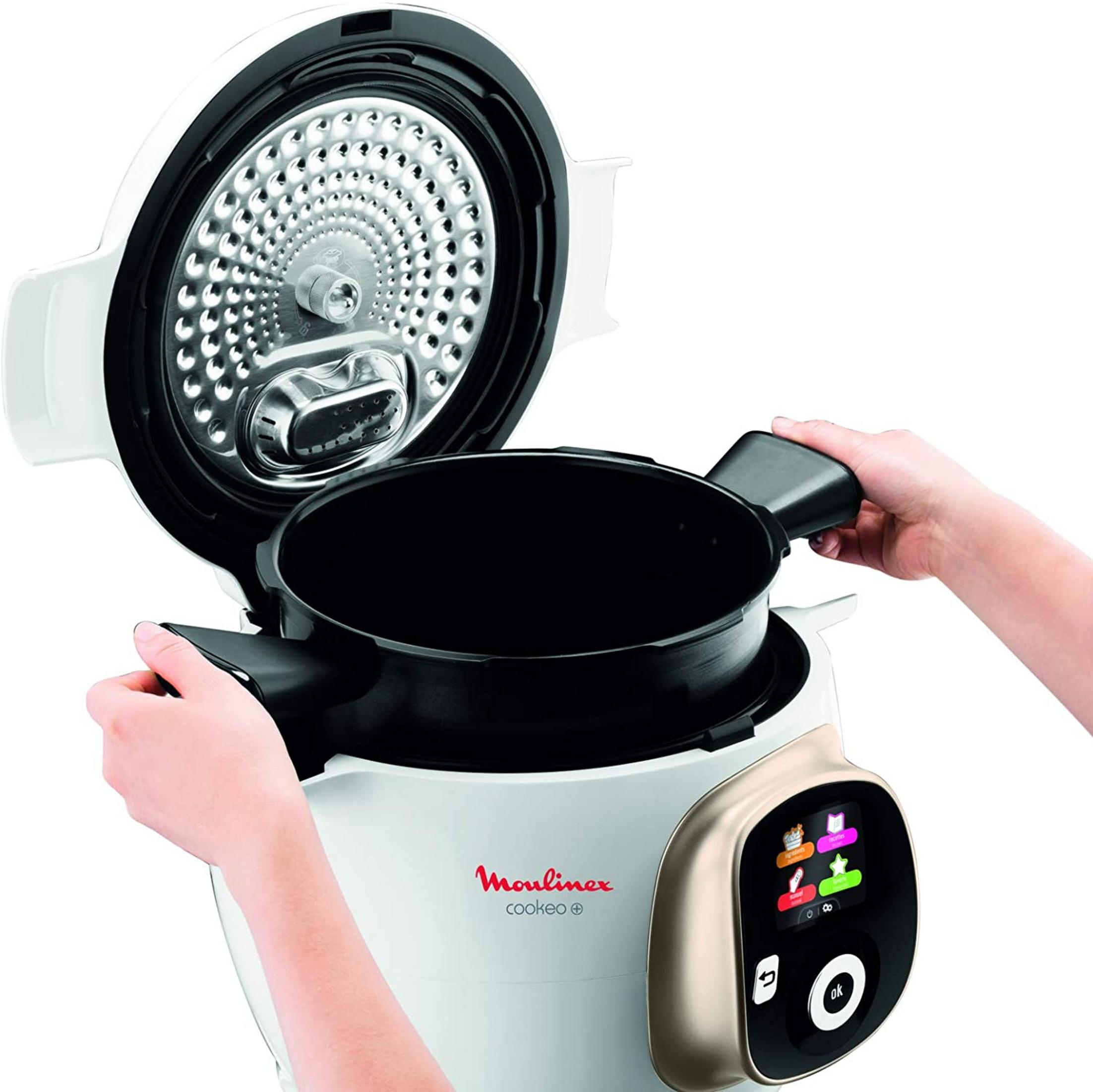Una persona abre una olla a presión Moulinex Cookeo blanca con un inserto negro.
