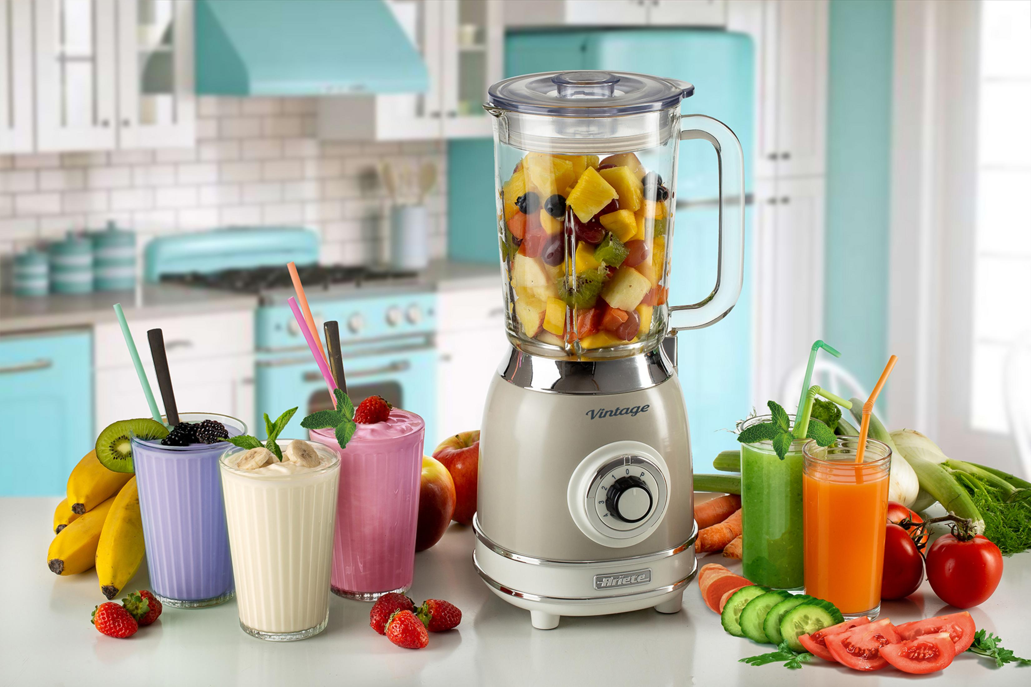 Meyveli vintage blender ve dört bardak smoothie ve meyve suyu.