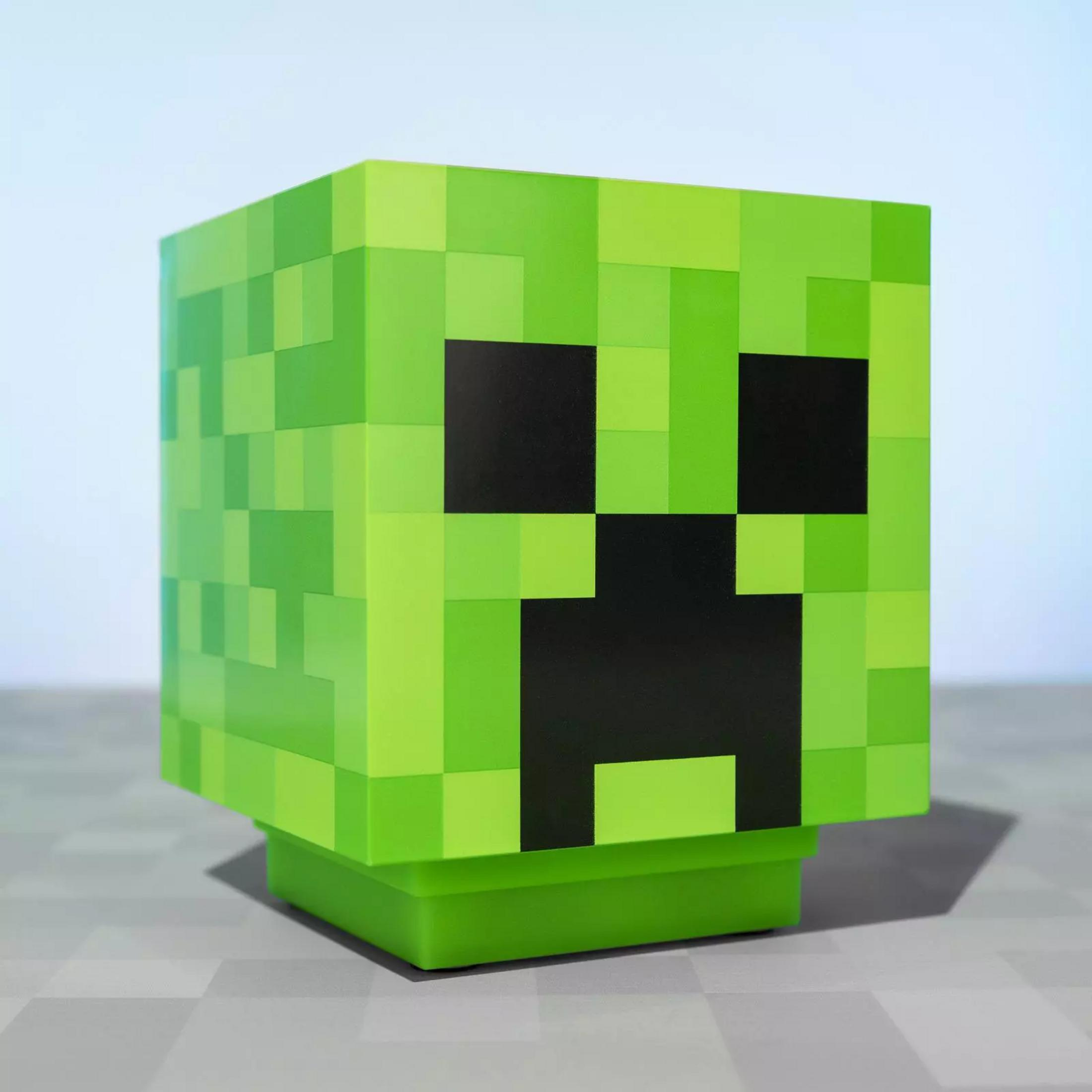 Zielona głowa Creepera z Minecraft stoi na cokole.
