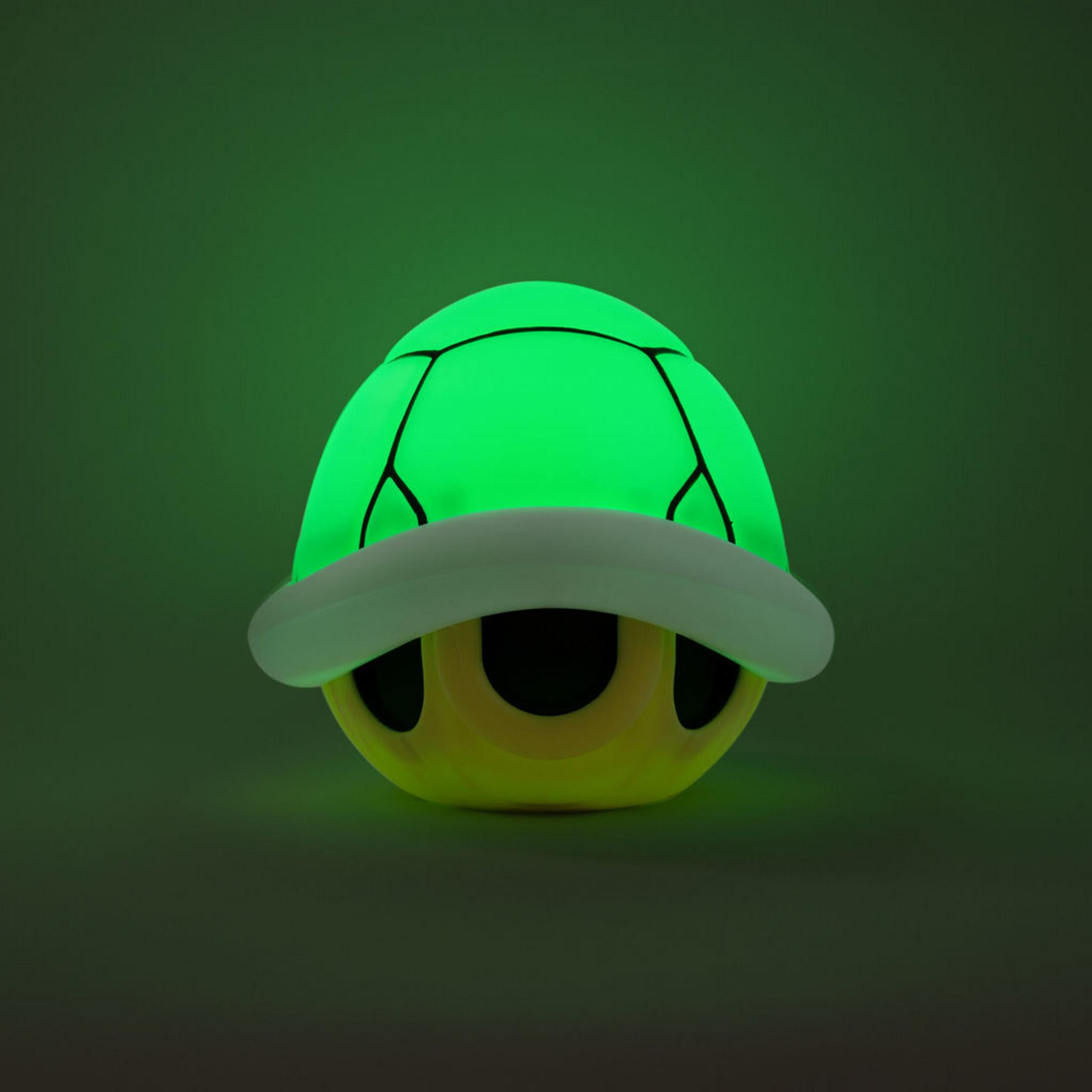 Eine leuchtend grüne Schildkrötenpanzerlampe mit gelben Augen und weißem Rand.