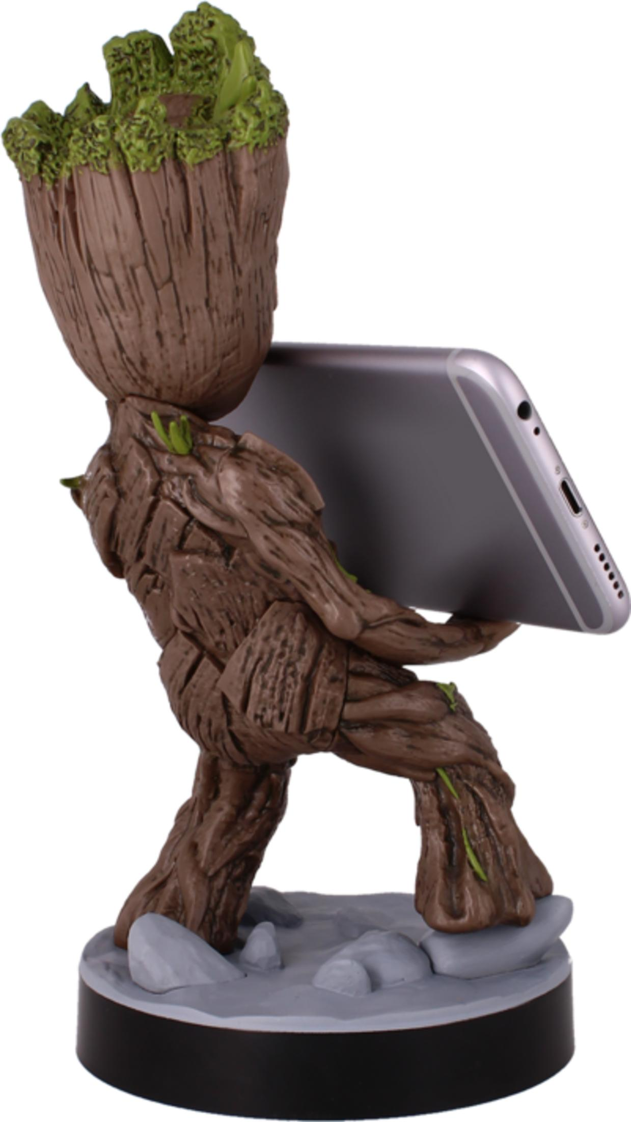 Statua di Groot che tiene uno smartphone, in piedi su una base rocciosa.