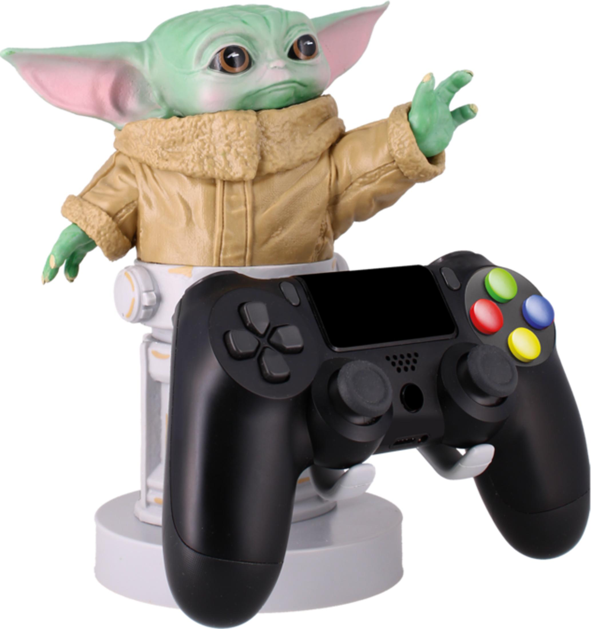 Una figura di Baby Yoda su un supporto bianco con un controller nero davanti.