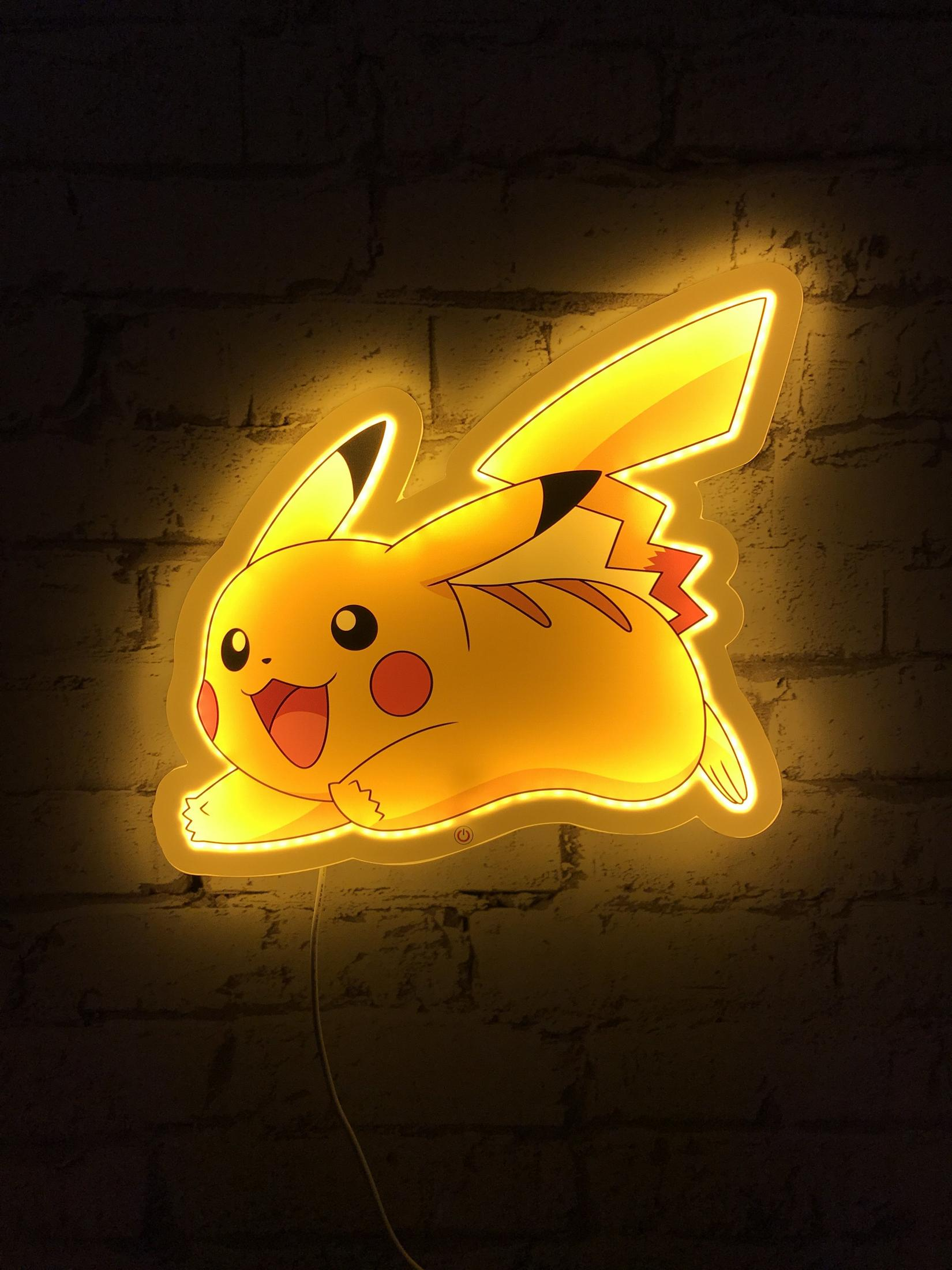 Leuchtende Pikachu-Neonlampe an einer Ziegelwand im Dunkeln.
