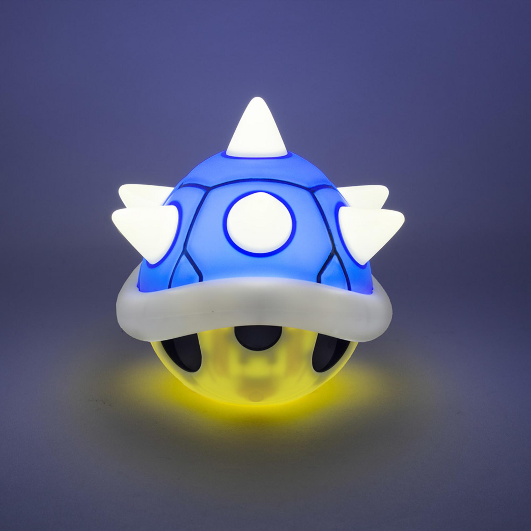 Una lámpara de caparazón azul brillante con púas blancas y base amarilla.