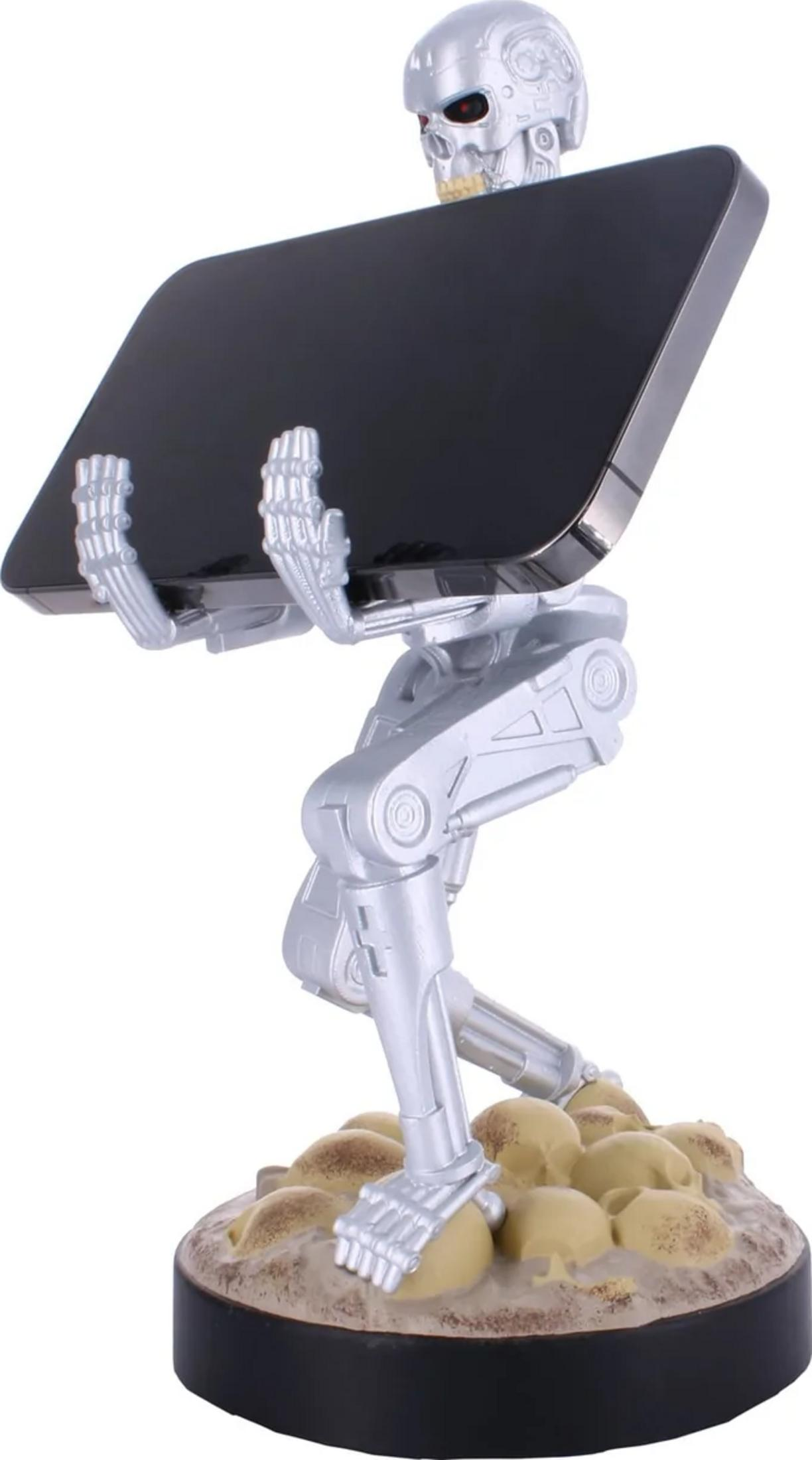 Silberner Terminator-Ständer hält ein schwarzes Smartphone auf einem Sockel mit Totenköpfen.