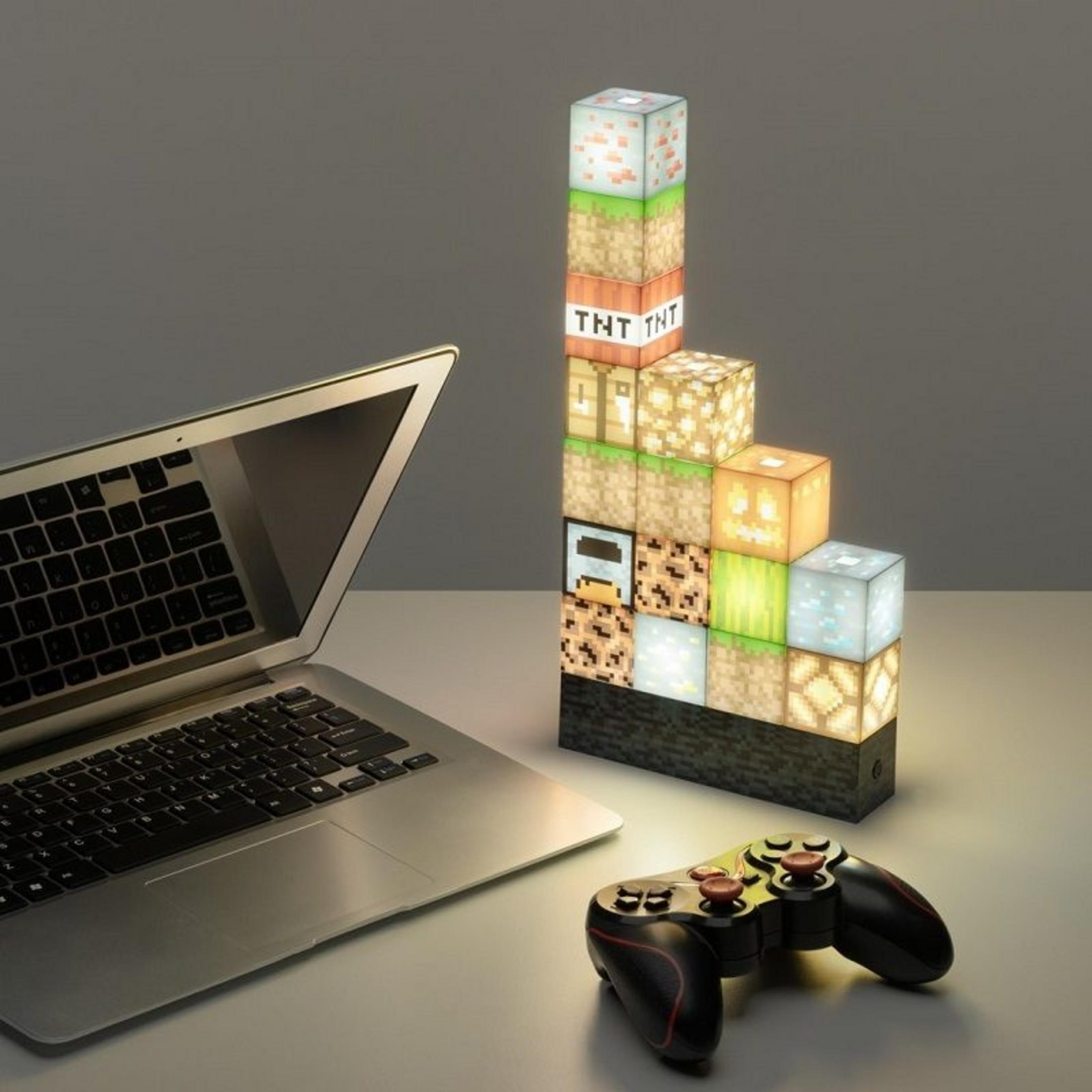 Ein Laptop, ein Controller und Minecraft-Blöcke als Lampe stehen auf einem Tisch.