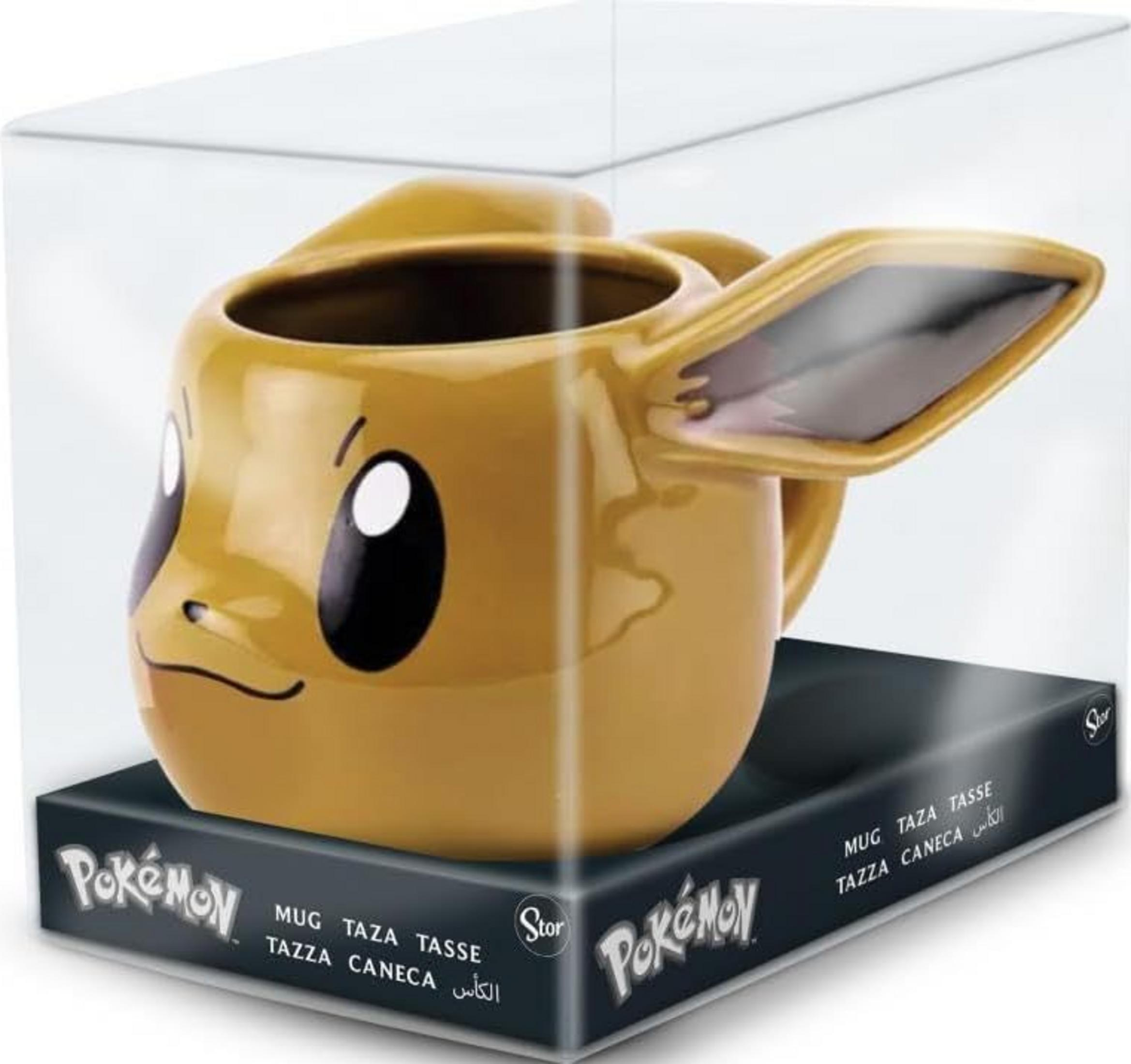 Gelbe Evoli-Tasse mit Gesicht, in transparenter Verpackung mit Pokémon-Logo.