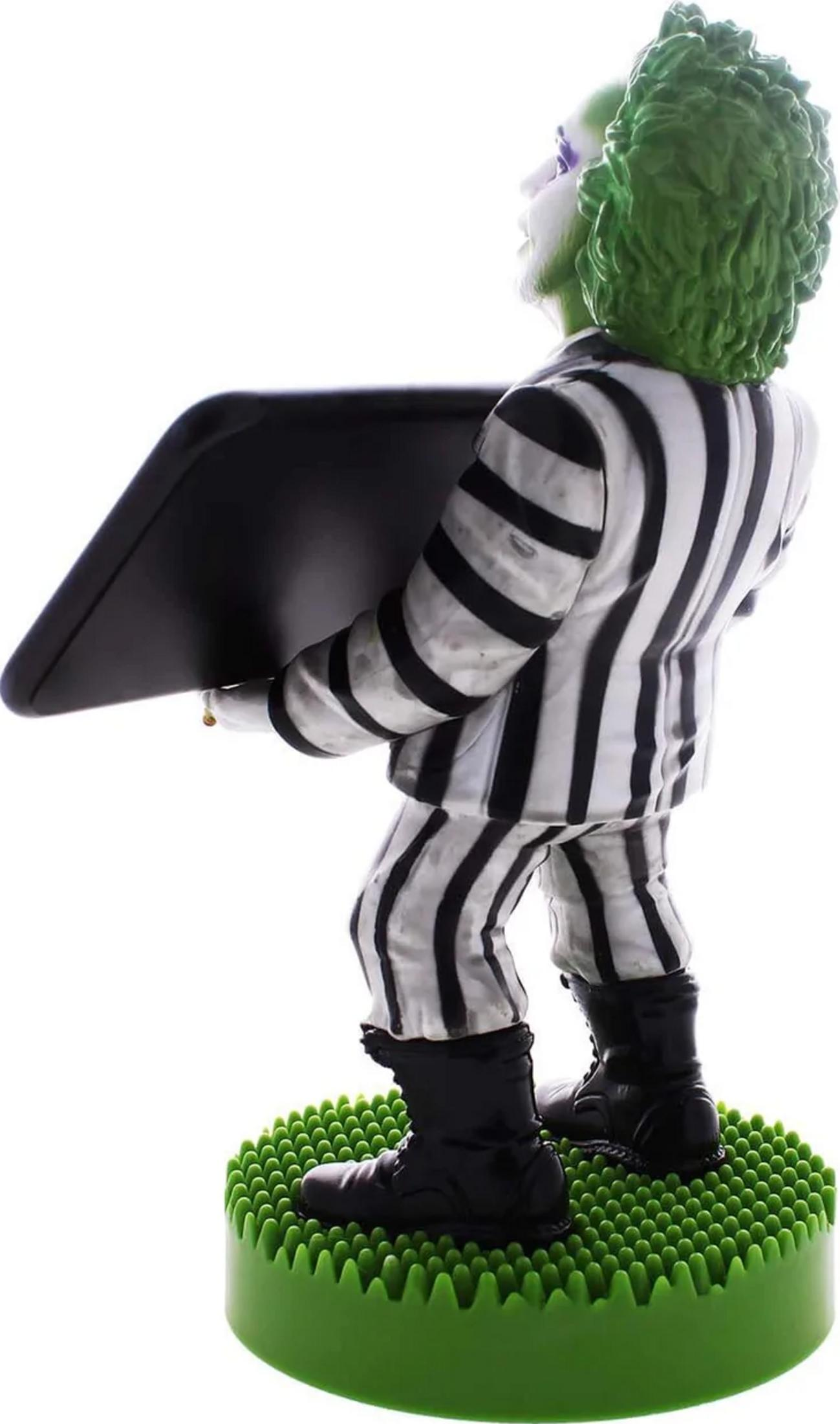 Beetlejuice Figur mit grünem Haar, schwarz-weißer Anzug, hält schwarzes Brett.