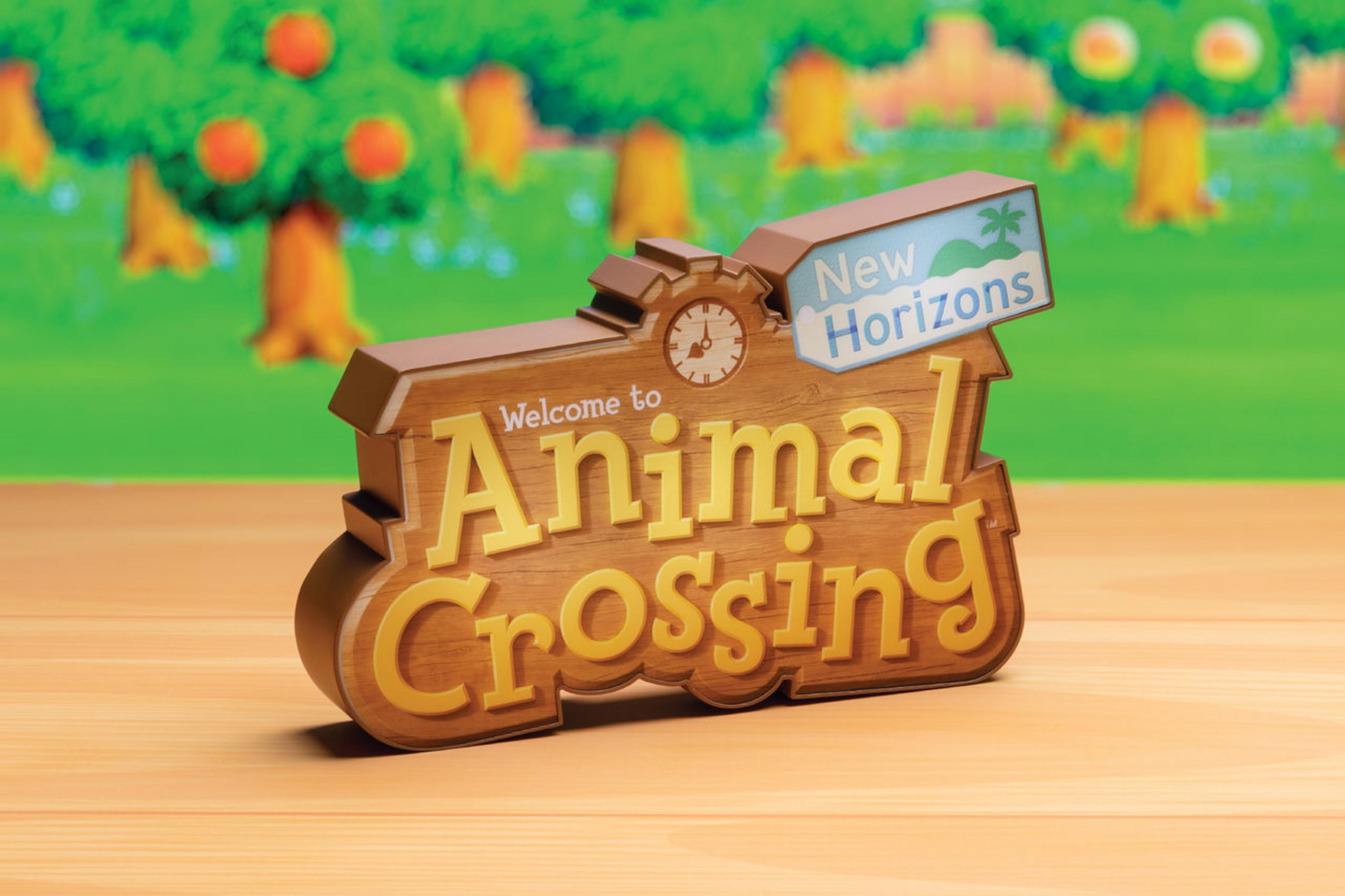 Benvenuti al logo di Animal Crossing New Horizons su tavolo di legno, sfondo verde.