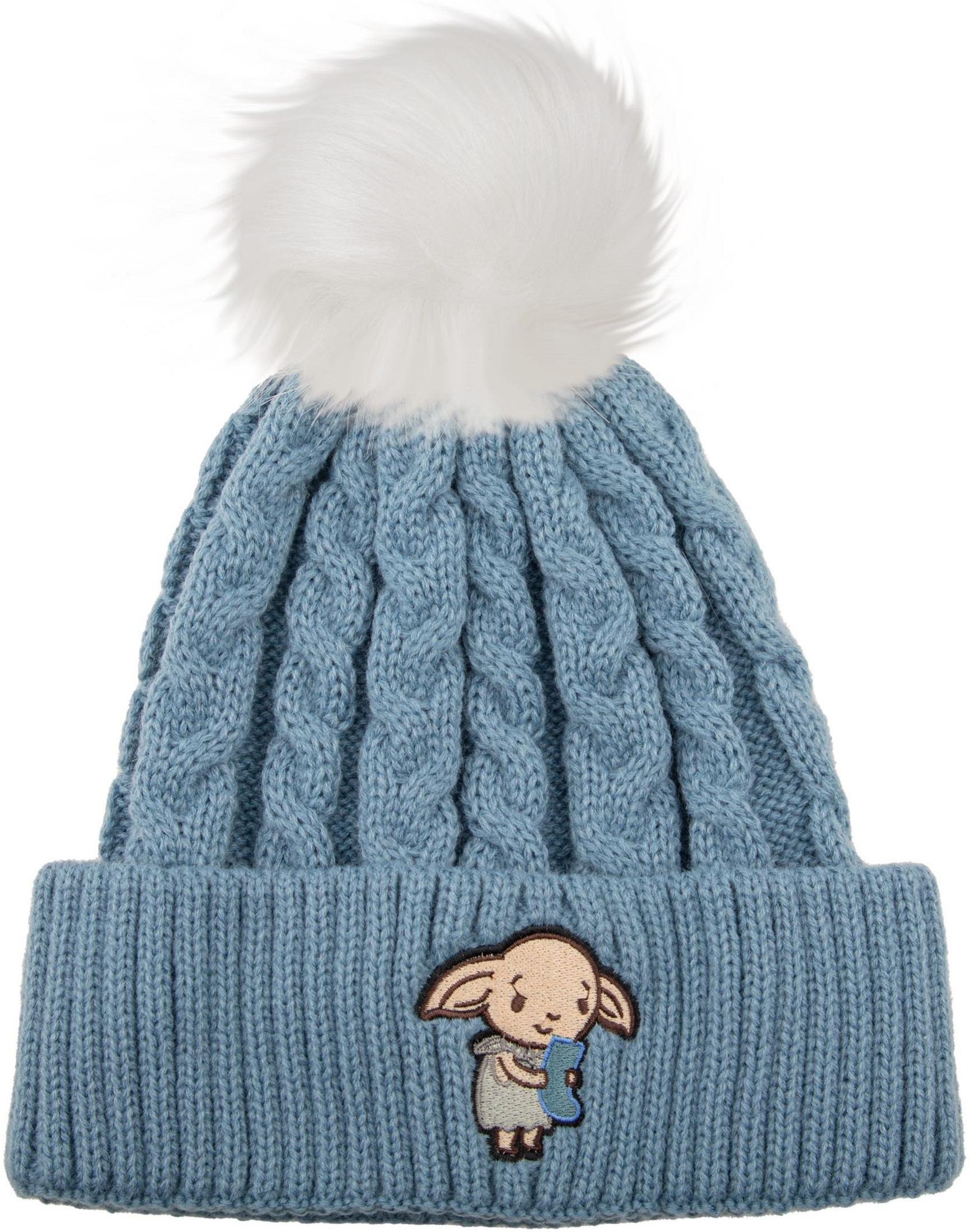 Eine blaue Strickmütze mit Zopfmuster und einem weißen Bommel. Unten ist eine Figur aufgestickt.